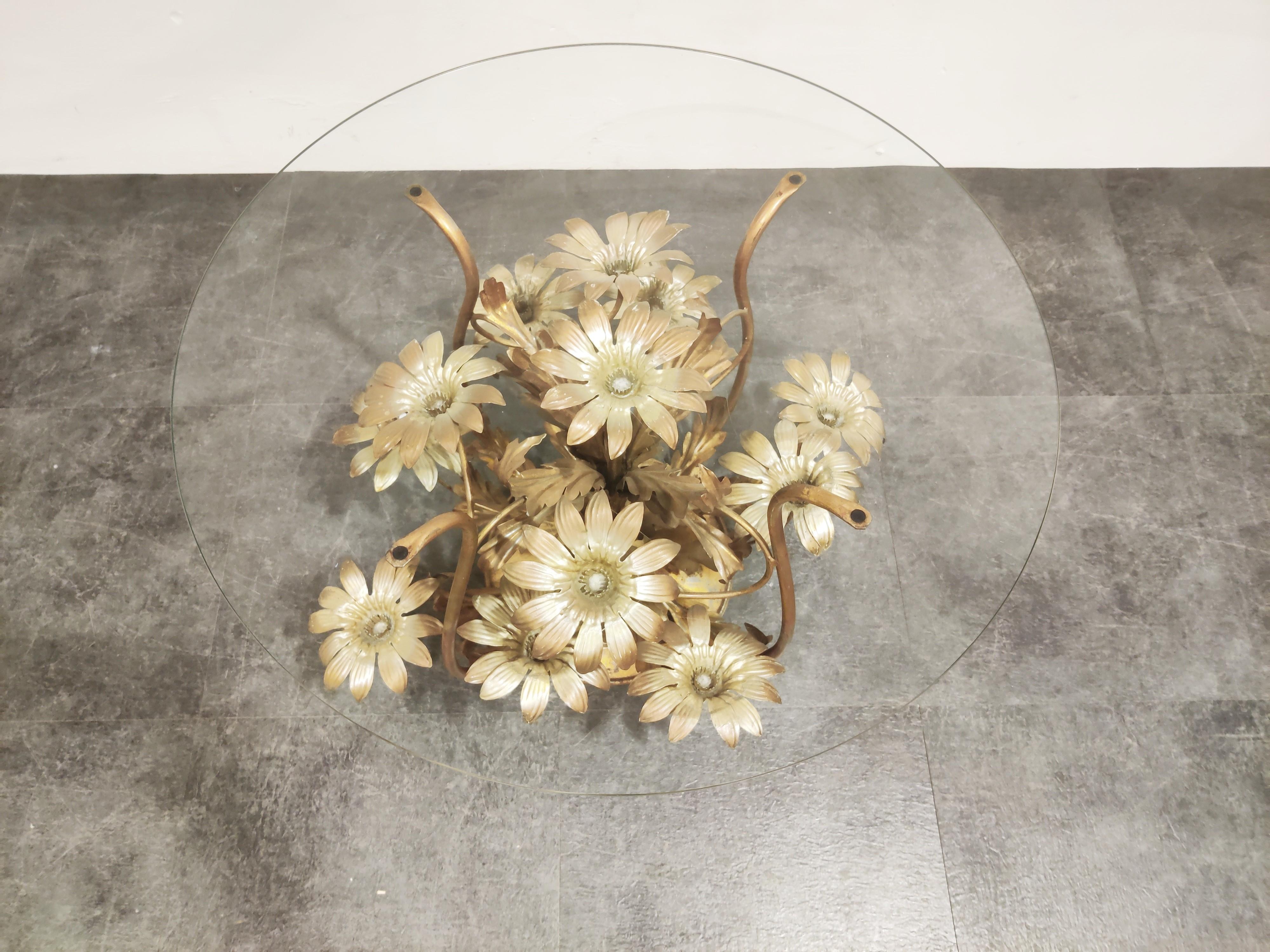 Charming metal flower coffee table with a round clear glass top.

The table was manufactured in Italy.

Beautiful elegant look which brings a touch of nature inside your home. 

Good condition, some paint loss.

1960s, Italy

Measures: