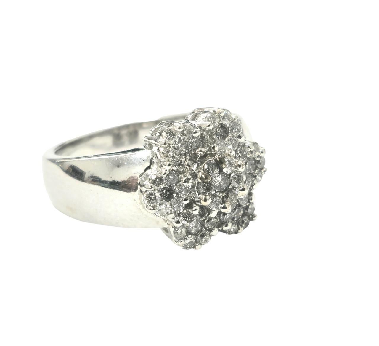 Zelebrieren Sie die Schönheit zarter Blütenblätter mit unserem exquisiten Vintage-Diamantring für Damen, der aus 14 Karat Weißgold gefertigt ist. Geschmückt mit runden Diamanten im Brillantschliff in einer Zackenfassung, strahlt dieses