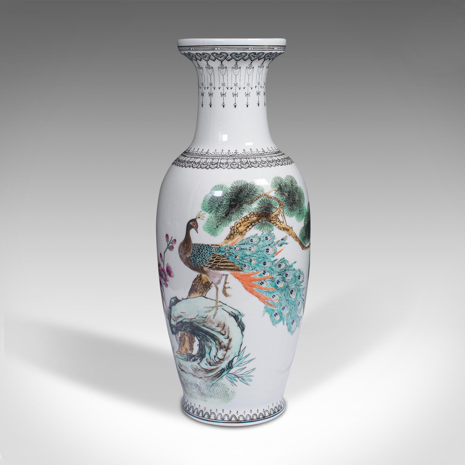 Dies ist eine alte Blumenvase. Chinesische Zierurne aus Keramik mit Pfauendekor aus der Mitte des 20. Jahrhunderts, um 1960. 

Fröhlich detaillierte Vase mit offenkundig orientalischem Geschmack
Mit einer wünschenswerten gealterten Patina