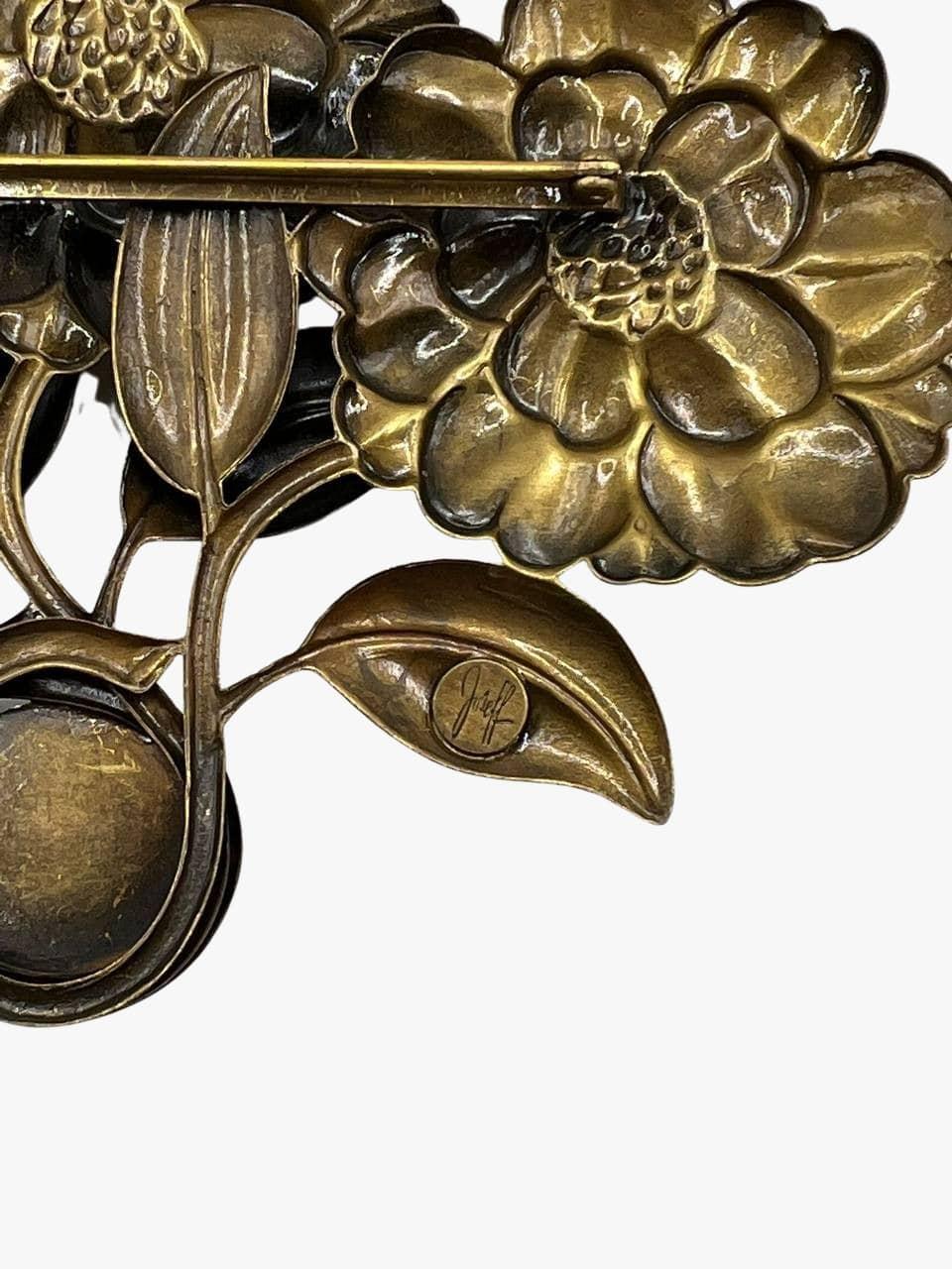Broche vintage de Joseff of Hollywood représentant un bouquet de 3 fleurs en métal bronze antique. 
Accentué par des pierres de verre vert émeraude et bleu. 
Signé. 
Période : 1950s
Condit : excellent. Aucun signe visible d'usure. 
Taille : 13,7cm x