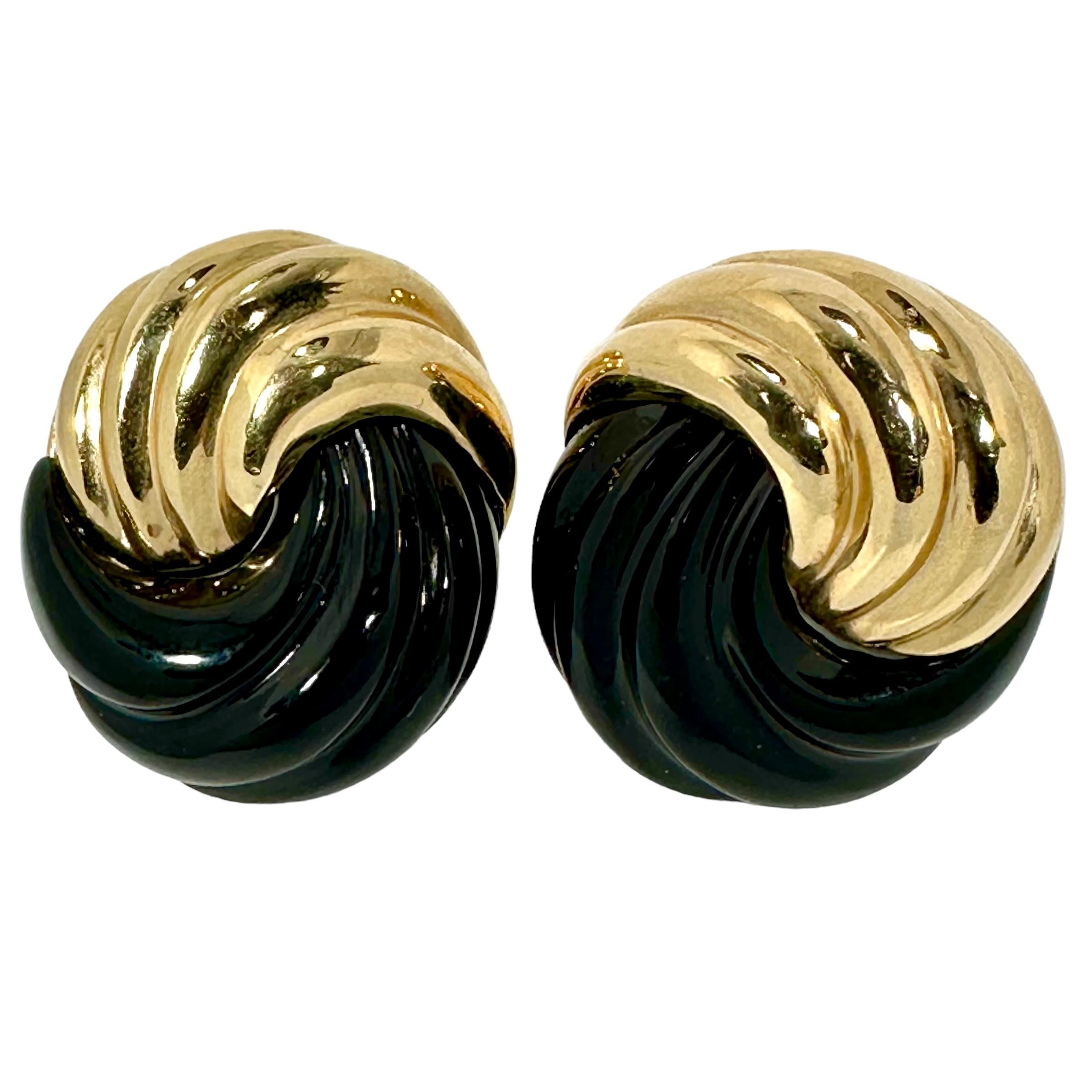 This visually exciting pair of vintage MAZ designer clip on earrings, created from fluted, 14k yellow gold and fluted, black onyx are crafted in the manner of a very dimensional knot.  With a measure of 1 1/8 inches in height by 1 inch in width,