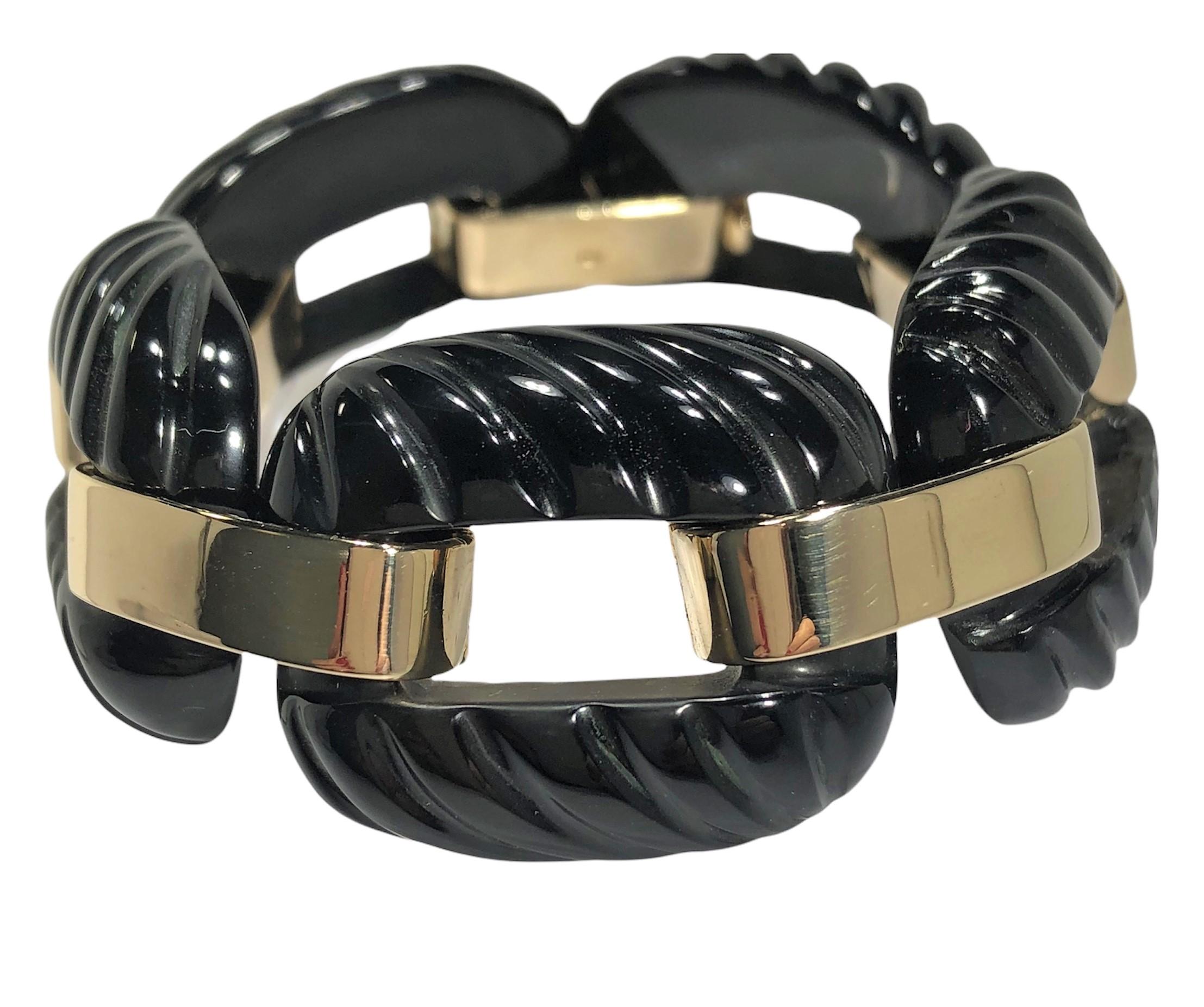 This tailored, classic bracelet features five individual fluted. black onyx links with 14K yellow gold connectors. 
Each link measures 1 1/4 inches long by  1 inch wide. Total length is 7 inches, however, with the large size of
the links, the