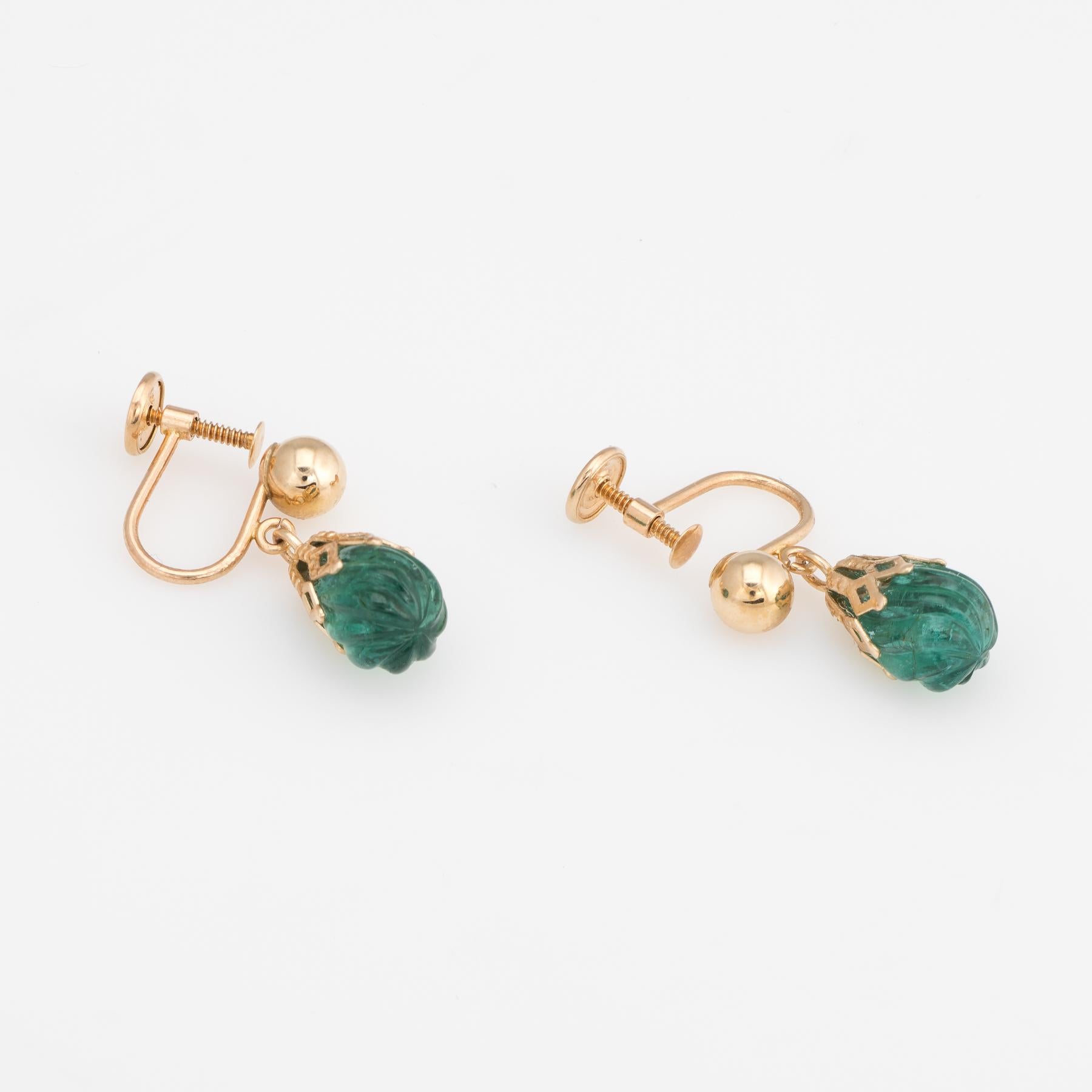 Elegant pair of vintage earring drops, crafted in 14k yellow gold. 

Fluted emeralds measure 10mm x 6.5mm. The emeralds are fluted with a slight twist. 

The gemstones are each securely set into triangular basket mounts. The earrings offer a nice