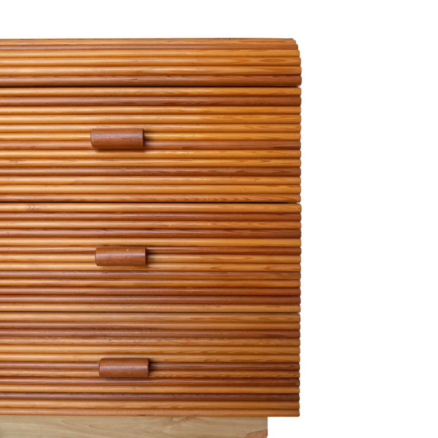 This unique vintage 1970s reed wrapped dresser features round-down pulls and a golden red oak finish. The smooth finished sides feature a slightly lighter finish atop a set-back plinth base. Wear is consistent with age and use. See photos for