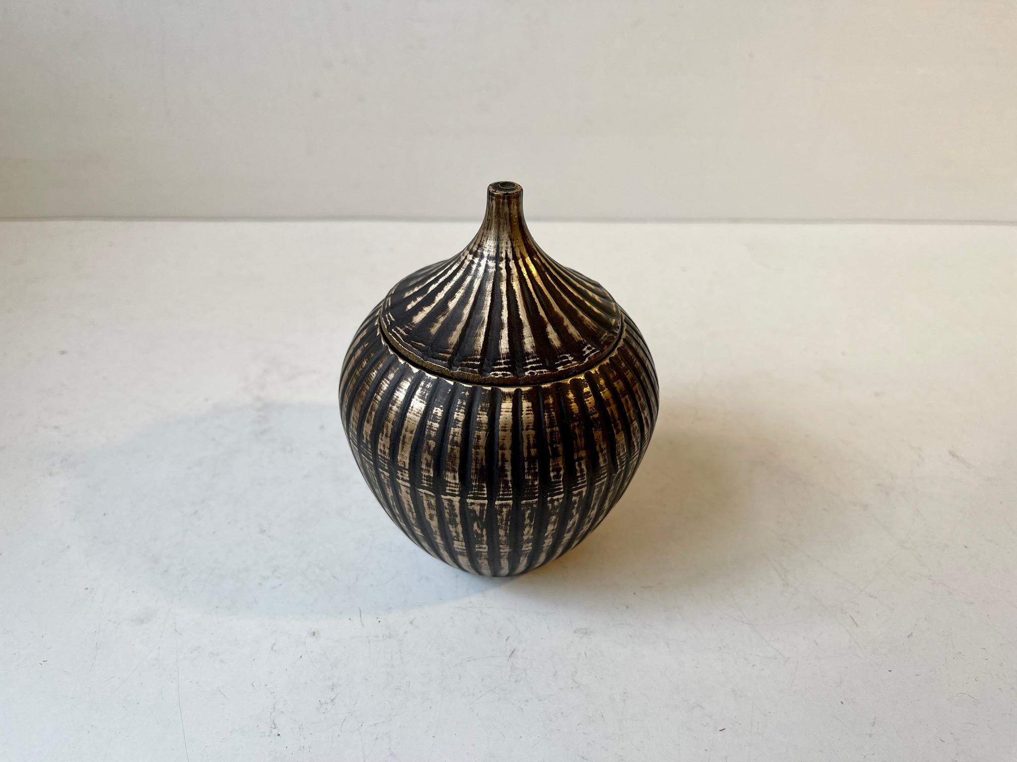 Decorative jar, lidded vase or trinket in solid brass. Cast in the shape of an onion featuring fluted corpus. Partially exposed brass and partially covered with forced patina. Unknown Scandinavian maker in the style of Tinos/Vendor. Despite its