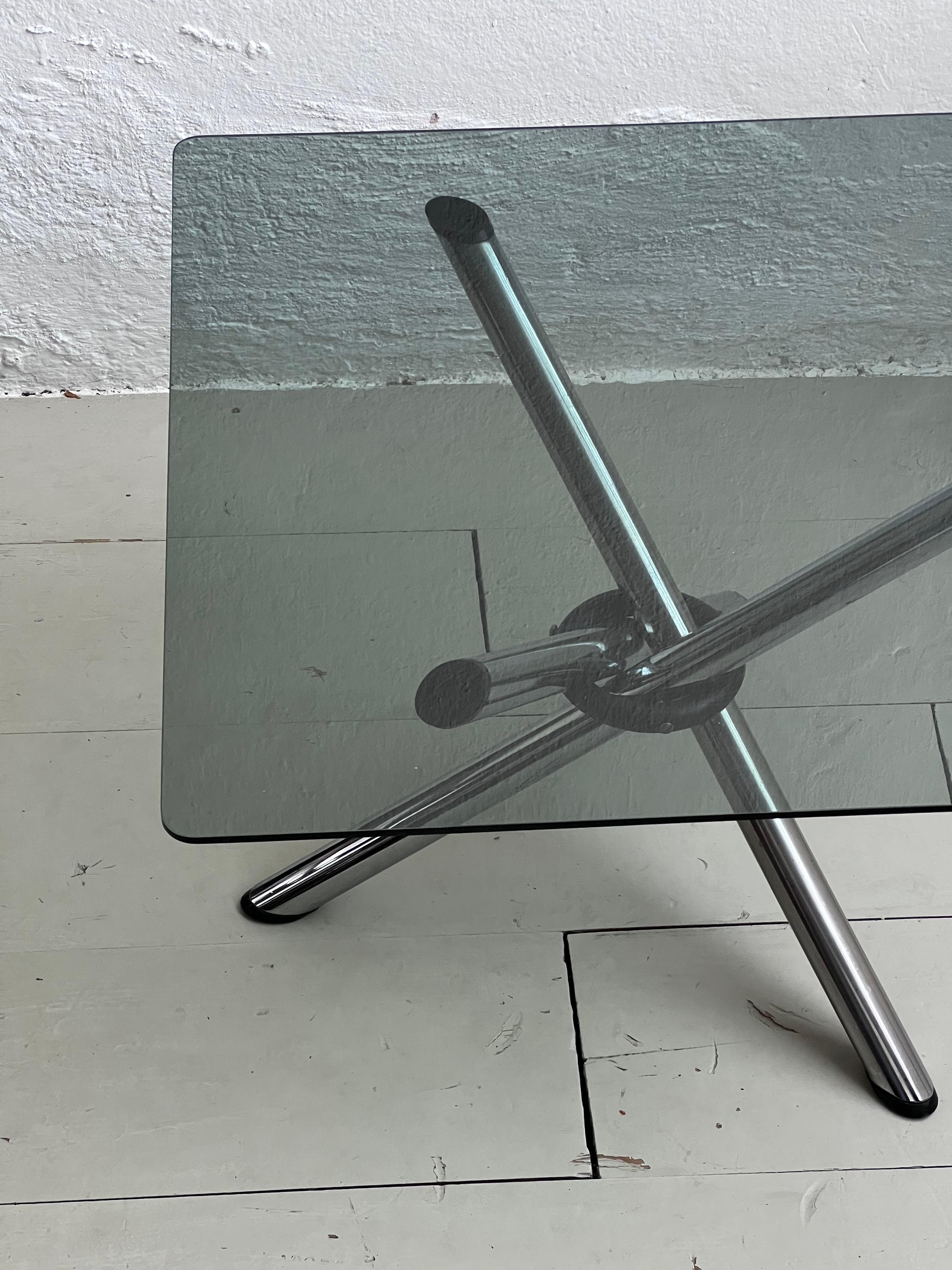 Vintage coffee table - Italian collectible cocktail table - foldable low table

A vintage 1970s coffee/cocktail table with three tubular legs in chromed metal and a square smoked glass top with rounded corners. Minimal in design and wise in