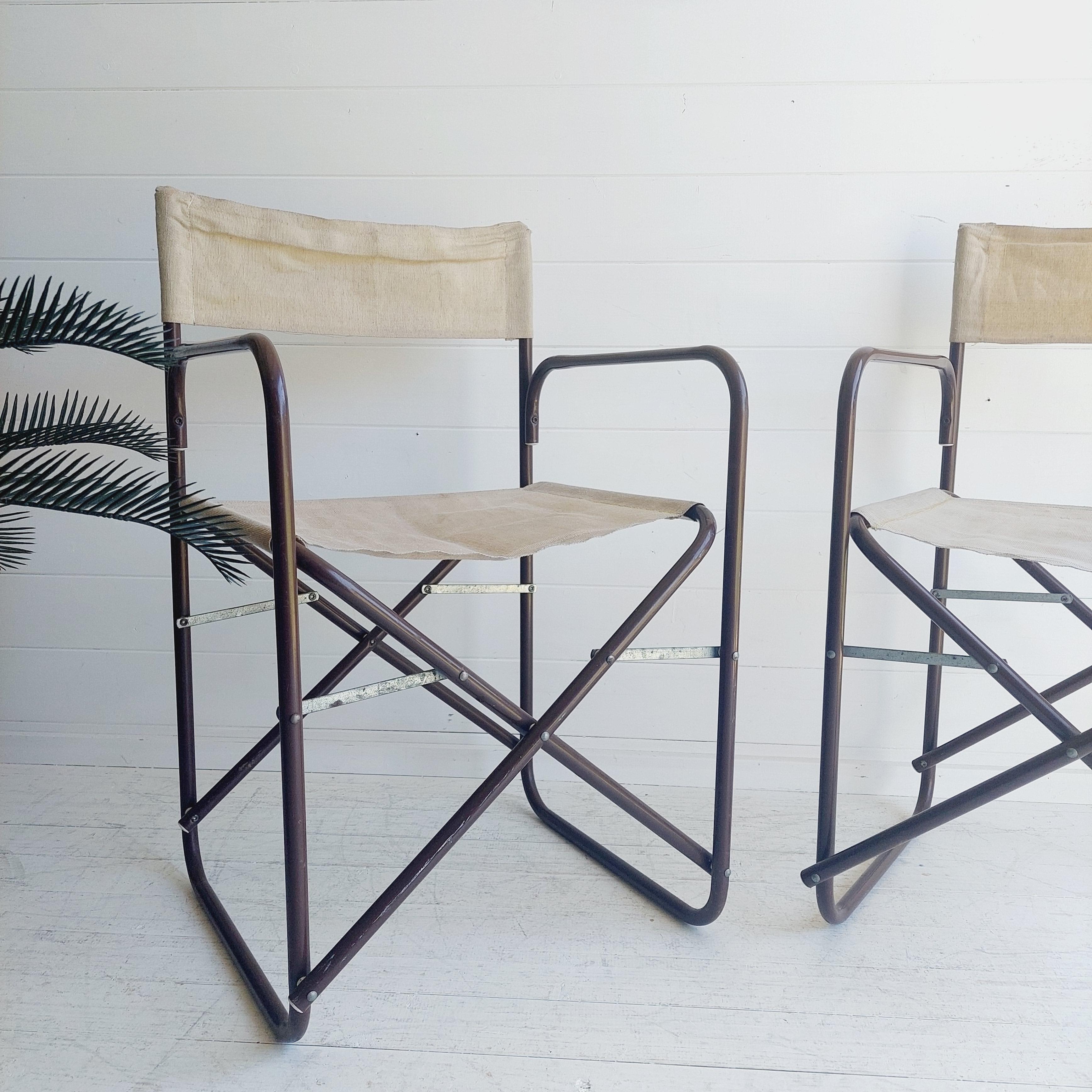 Handsome set of 2 folding Campaign style director’s chairs.
Mid century mordern design

Comprised of whaterproff beige canvas sling seats and back, and brown tubular metal frame.
Folds easily for storage. 
These are done in the style of Gae