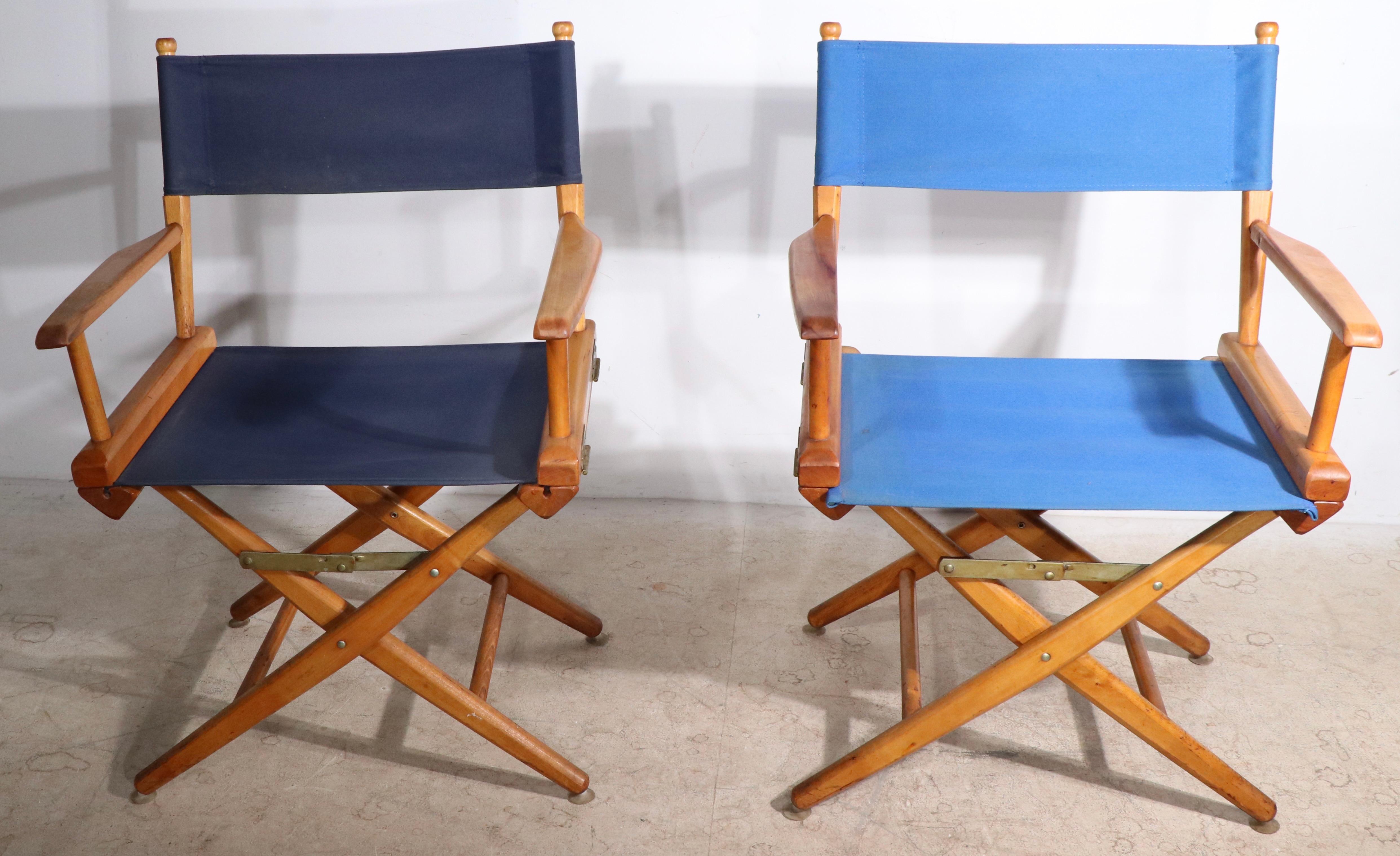 2 canvas and wood folding director chairs, each with canvas sling seat and back rests. Both chairs are in very good, original condition, clean and ready to use. One chair is a lighter shade of blue, the other is very dark blue.Please note both