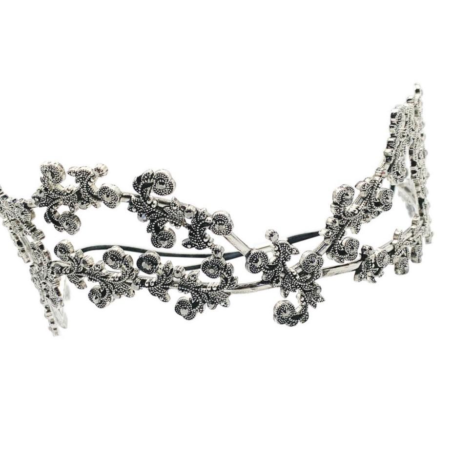 A vintage foliate tiara. Featuring foliate style swags decorated with tiny crystals.

Vintage Condition: Very good without damage or noteworthy wear.
Materials: blackened silver metal and glass crystals
Signed: unsigned
Fastening: elastic to hold in