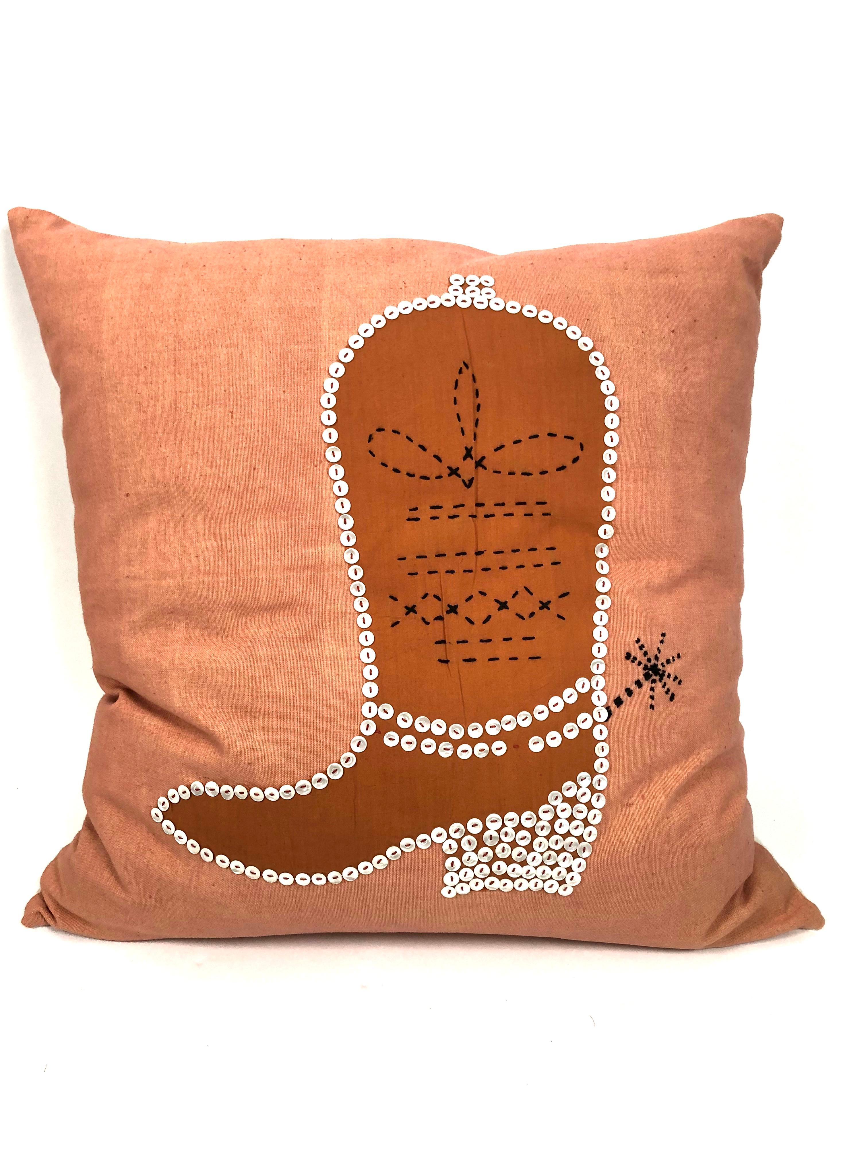 Handmade, one of a kind vintage pillows, with an appliqued burnt orange or rust colored cotton cowboy boot with spur, highlighted and decorated with black decorative embroidery and buttons, on a peach colored cotton field, with new down filling and