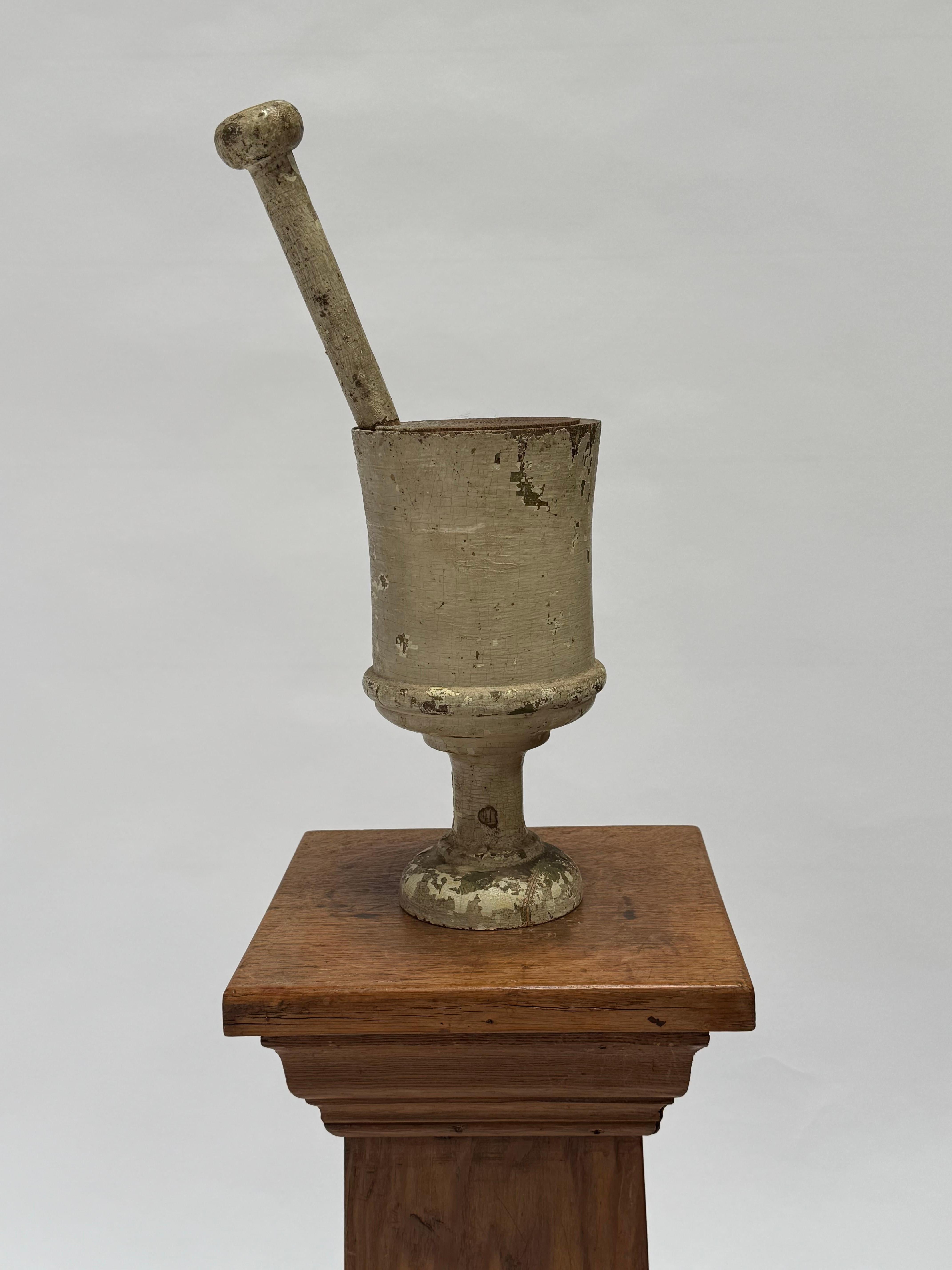 Late 19th early 20th Century Pharmacy sign wooden pestle and mortar, the piece shows the many years it was exposed to the elements with a fine patina becoming said piece. The paint is a soft white with cracking to the finish, a very nice rustic