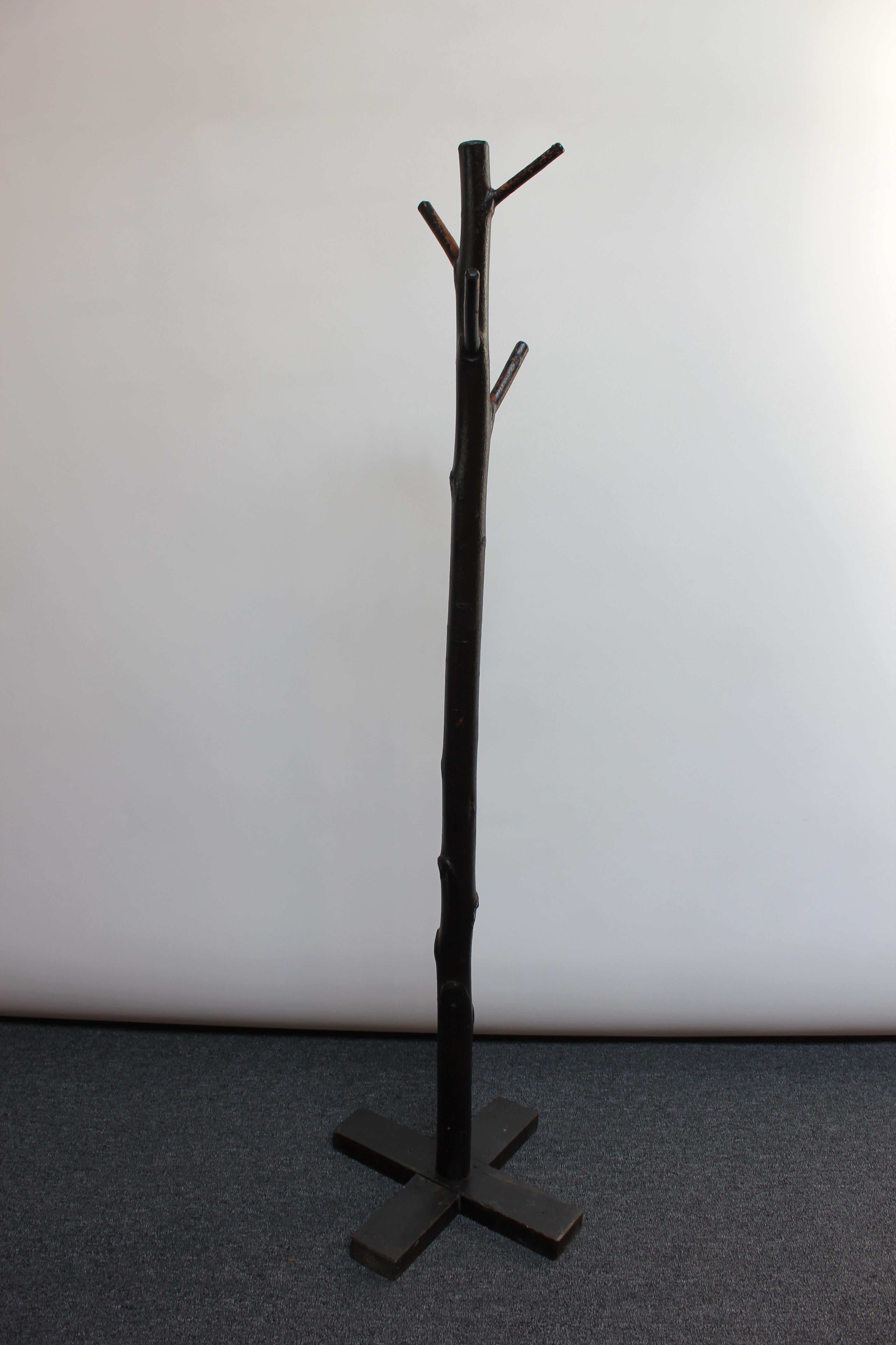 Impressive tree-form coat / hat rack, circa 1920s, composed of ebonized dry wood of an actual tree (likely cherry). Fitted to a carved wood base. Rich ebony color and marvelous texture with early hand hammered nails and spikes.