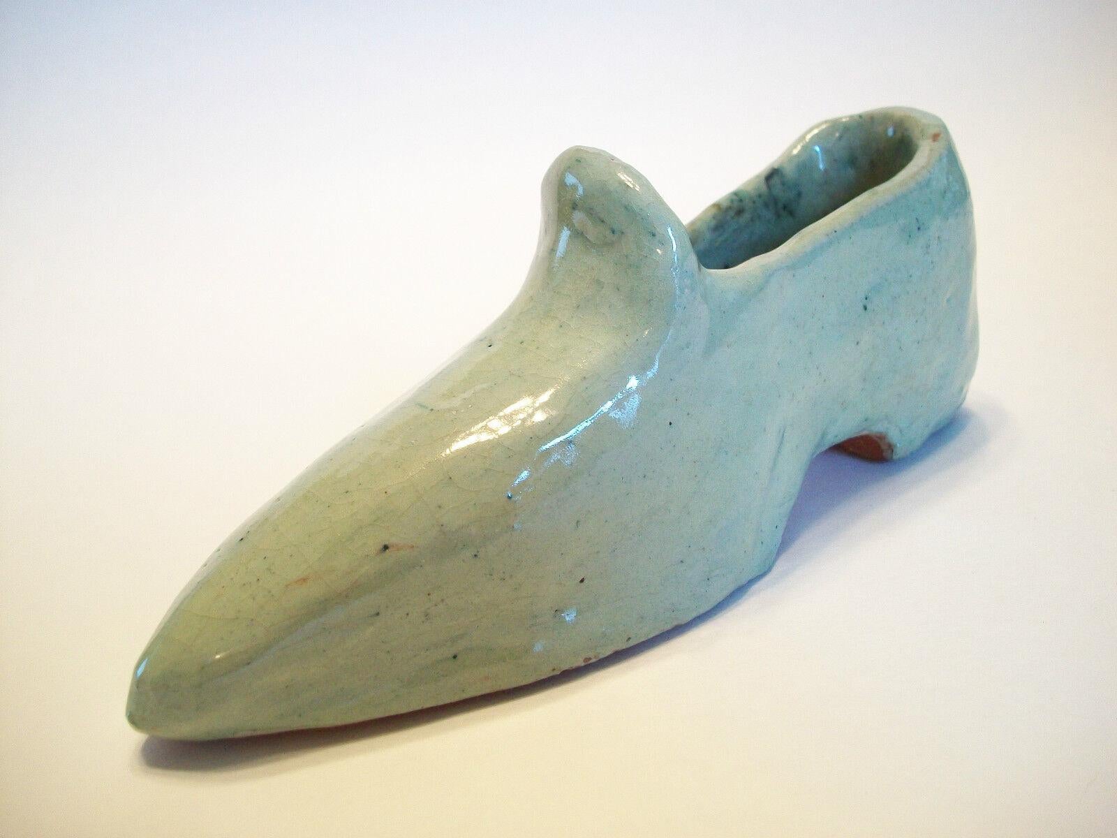 Vintage American folk art glazed terracotta shoe - hand modeled - signed and dated on the base - United States - circa 1966.

Good vintage condition - hand modeled body as intended by the artist - one firing crack (not affecting the structural