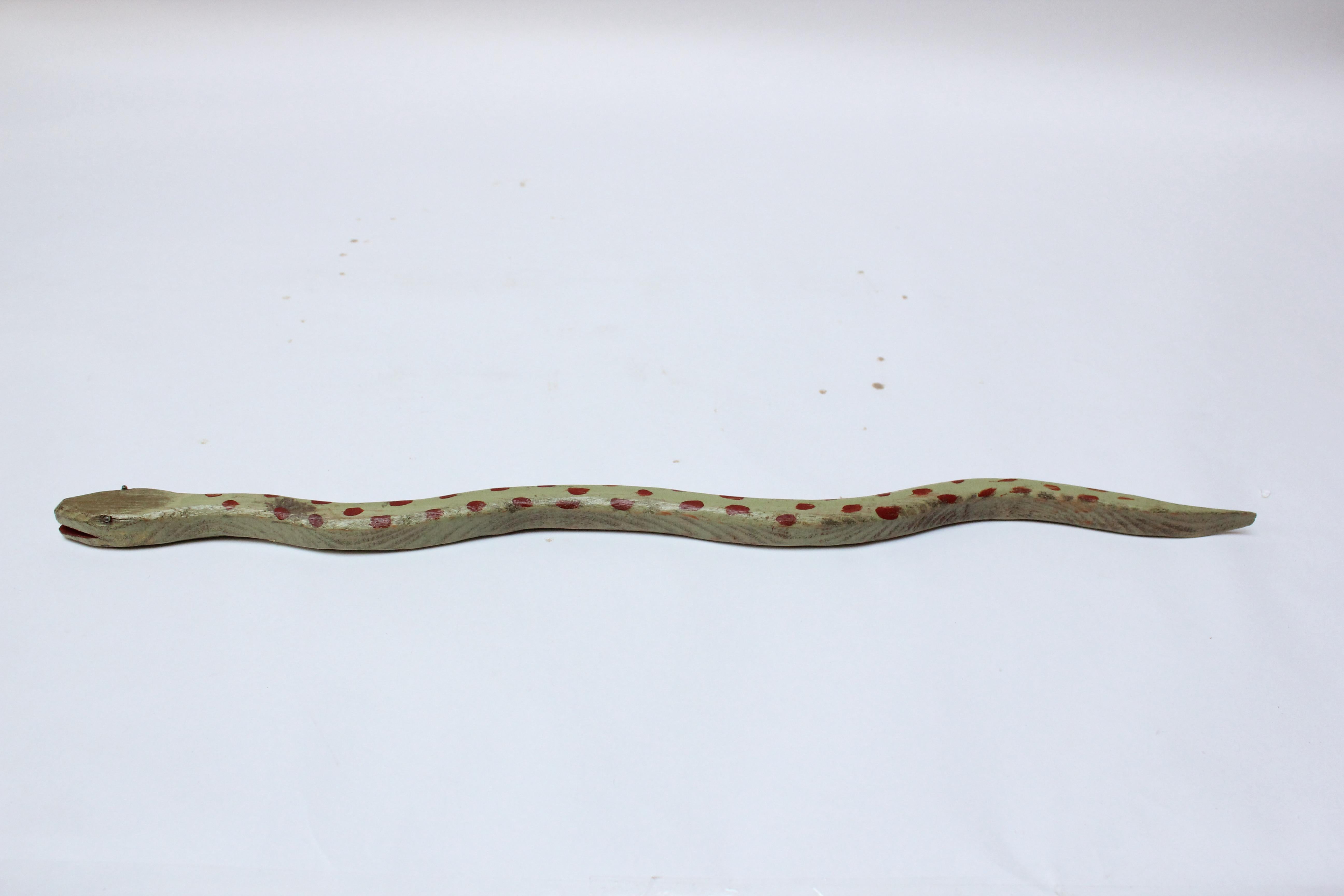 Hand-carved and painted folk art snake (ca. 1970s, USA). Attractive color combination of light green with red spots. Patina / light wear consistent with age and use.