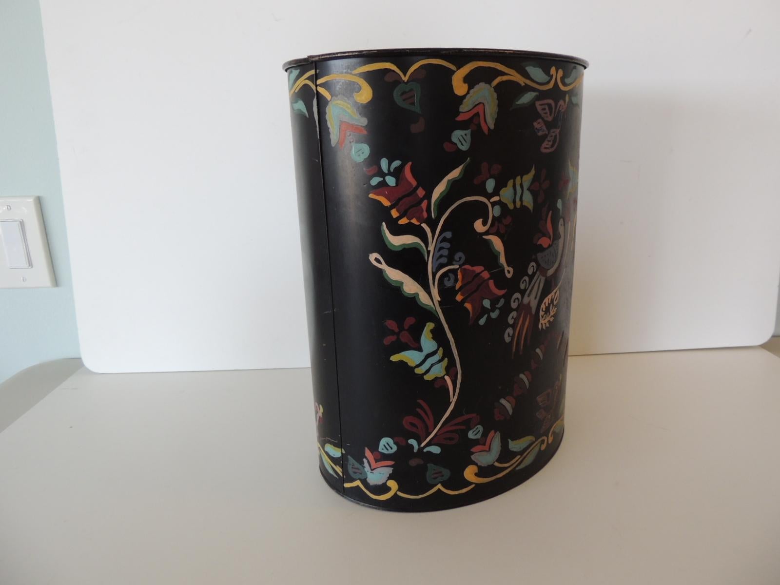 Vintage Folk Art style painted tin oval wastebasket
in black with pastel colors.
Size: 11.5