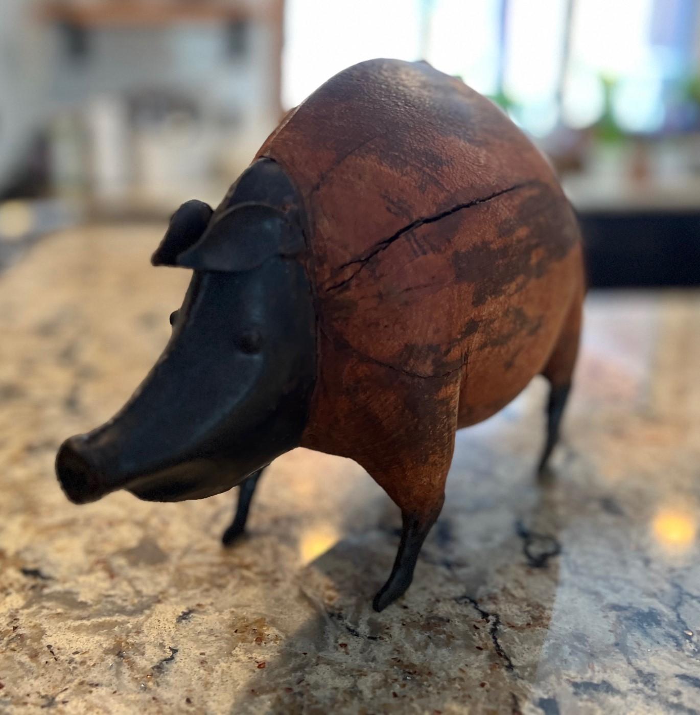 A vintage folk art style pig figure made of wood and tinplate. This is a cute piggy with a sweet face and lovely curly metal tail. The body is made of wood and it feels like a rugby ball to hold....obviously a well fed piggy. This character would be