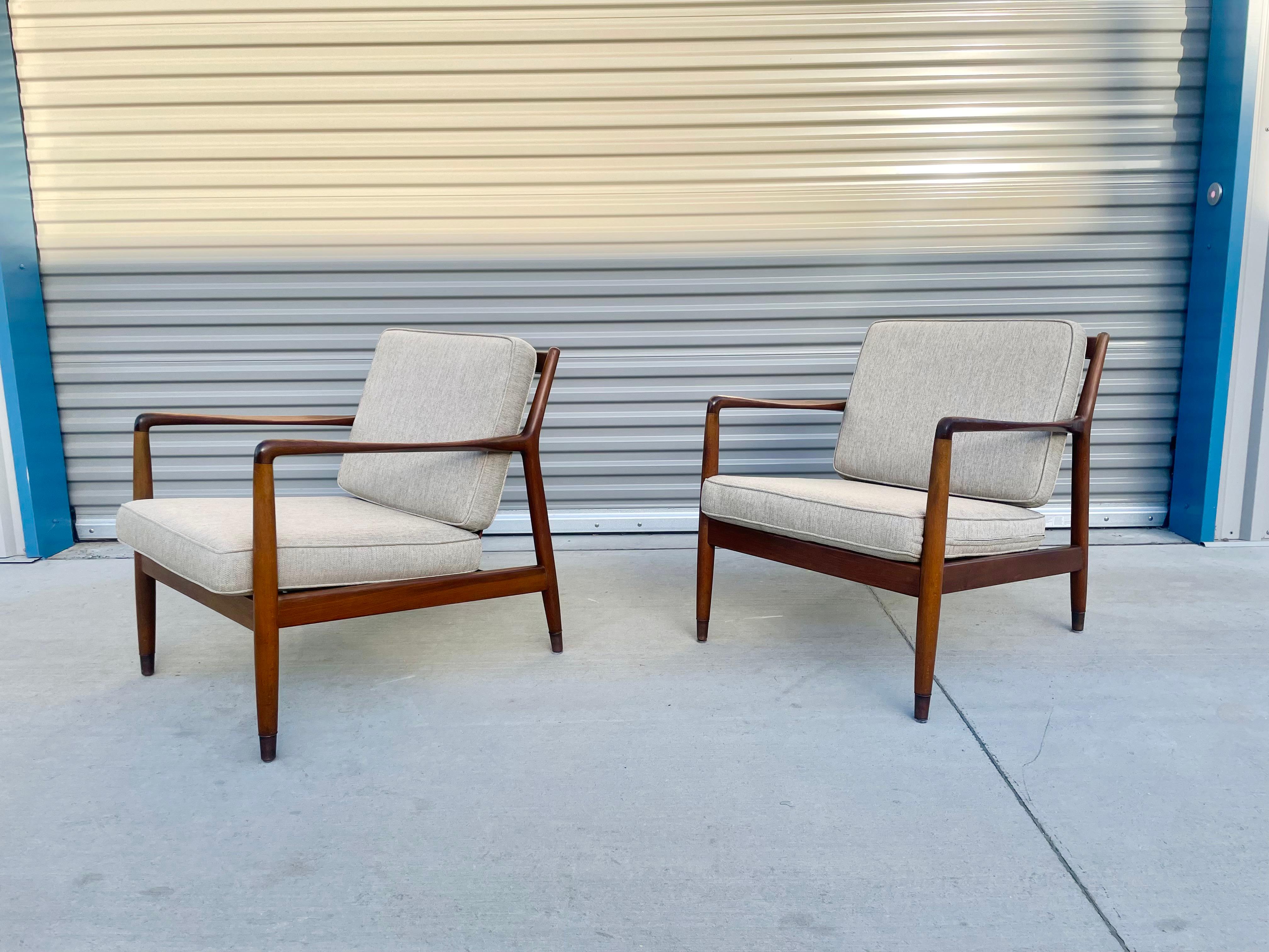 Vintage Folke Ohlsson model USA-143 lounge chairs manufactured by dux circa the 1950s. These mid-century lounge chairs were made of the highest quality walnut, giving them an excellent color tone and beautiful grain patterns. The chairs also feature