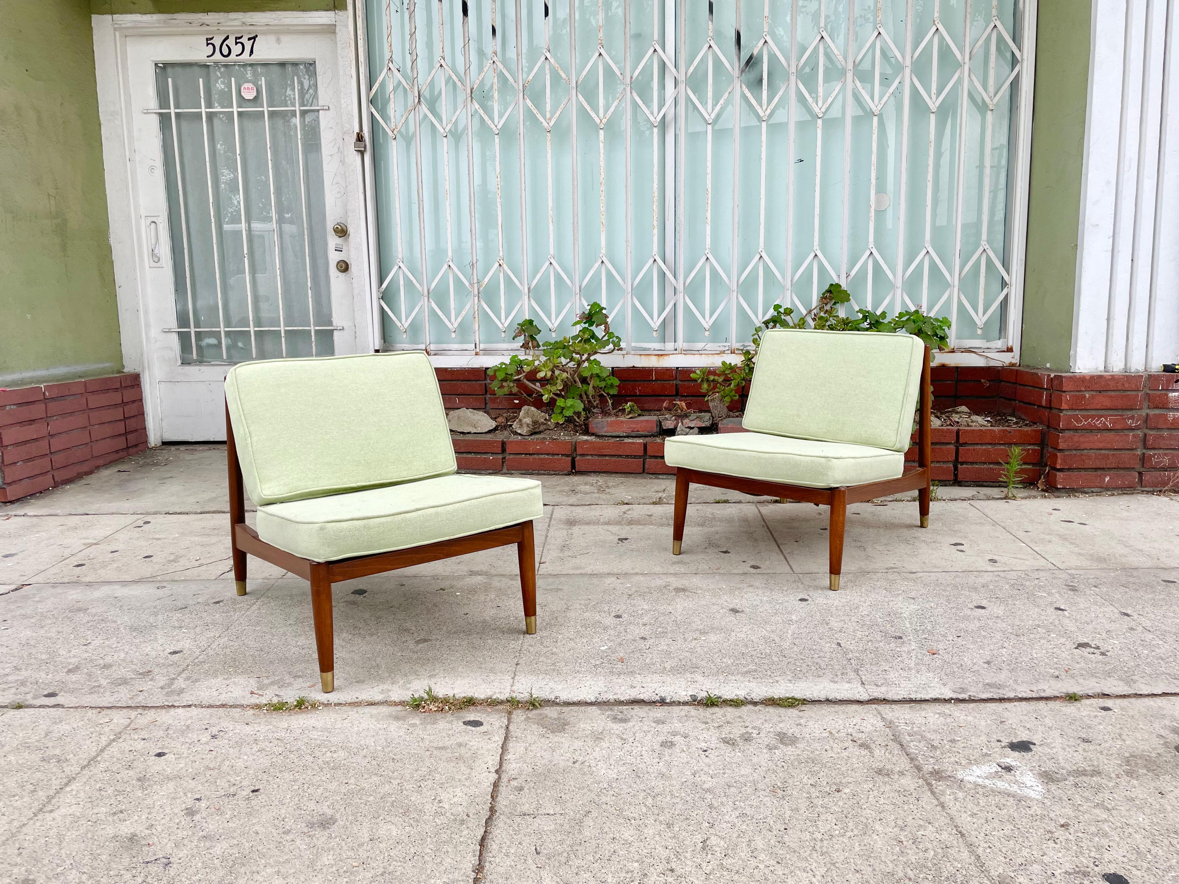 Folke Ohlsson slipper lounge chairs manufactured for dux in Sweden, circa 1950s. These danish modern lounge chairs were made of the highest quality walnut. The chairs also feature a walnut wood frame with five vertical slats in the back that provide