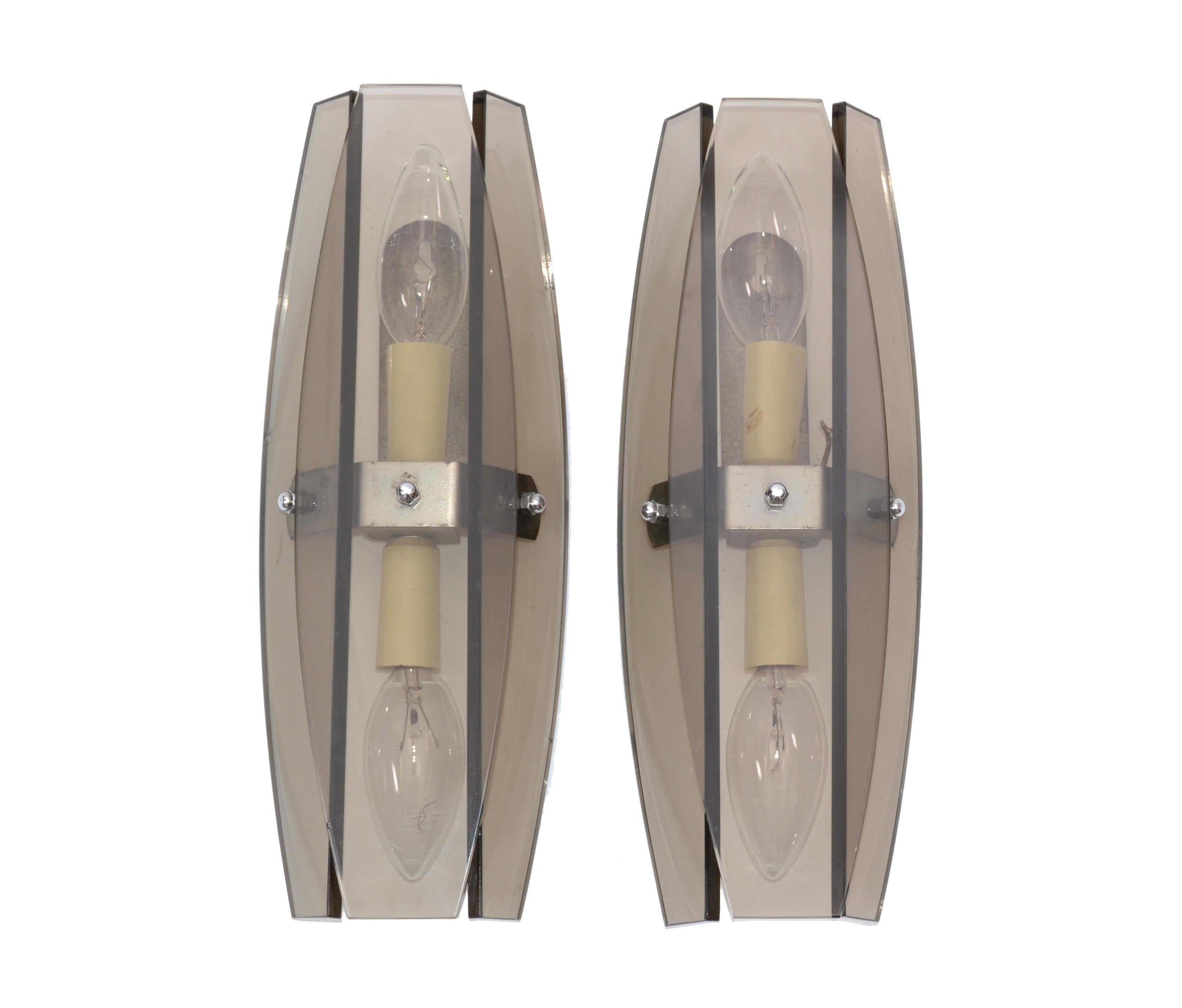 A pair of Italian Mid-Century Modern sconces by Fontana Arte featuring panels of smoked, beveled glass.
U.S. wired and in working condition.
Each sconce takes 2 x 40W bulb per sconce.
Back plate: 4 inches H. x 1.5 inches W.