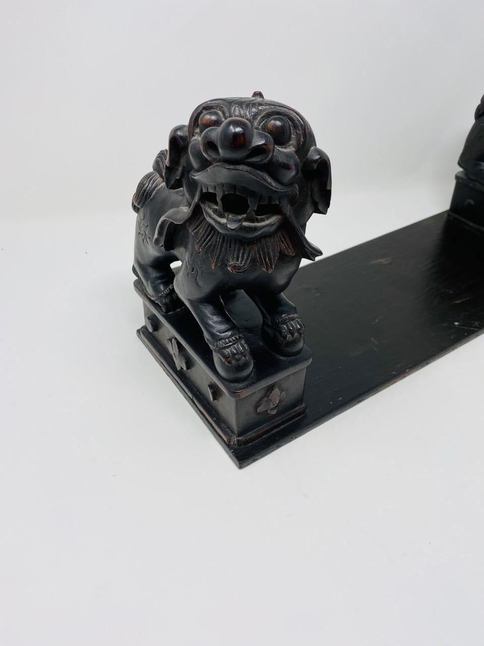 Vintage set of foo dogs mounted on a wood tray. These beautiful carved foo dogs rest on a conjoined tray that is ready for favorite titles or it can act as a decorative tray. The figures and finely carved and beautifully aged. This vintage set