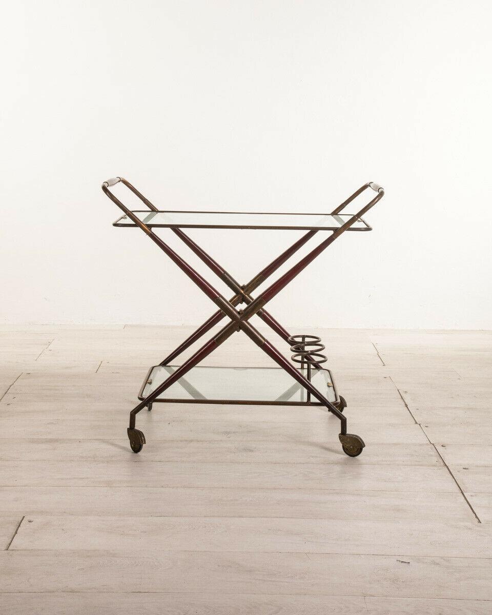 Food trolley in lacquered wood and gilded brass with two glass shelves with cup holder, resealable. Design Piero Fornasetti for Fornasetti, 1950s.

Conditions: In fair condition, it shows signs of wear due to time.

Dimensions: Height 75 cm;