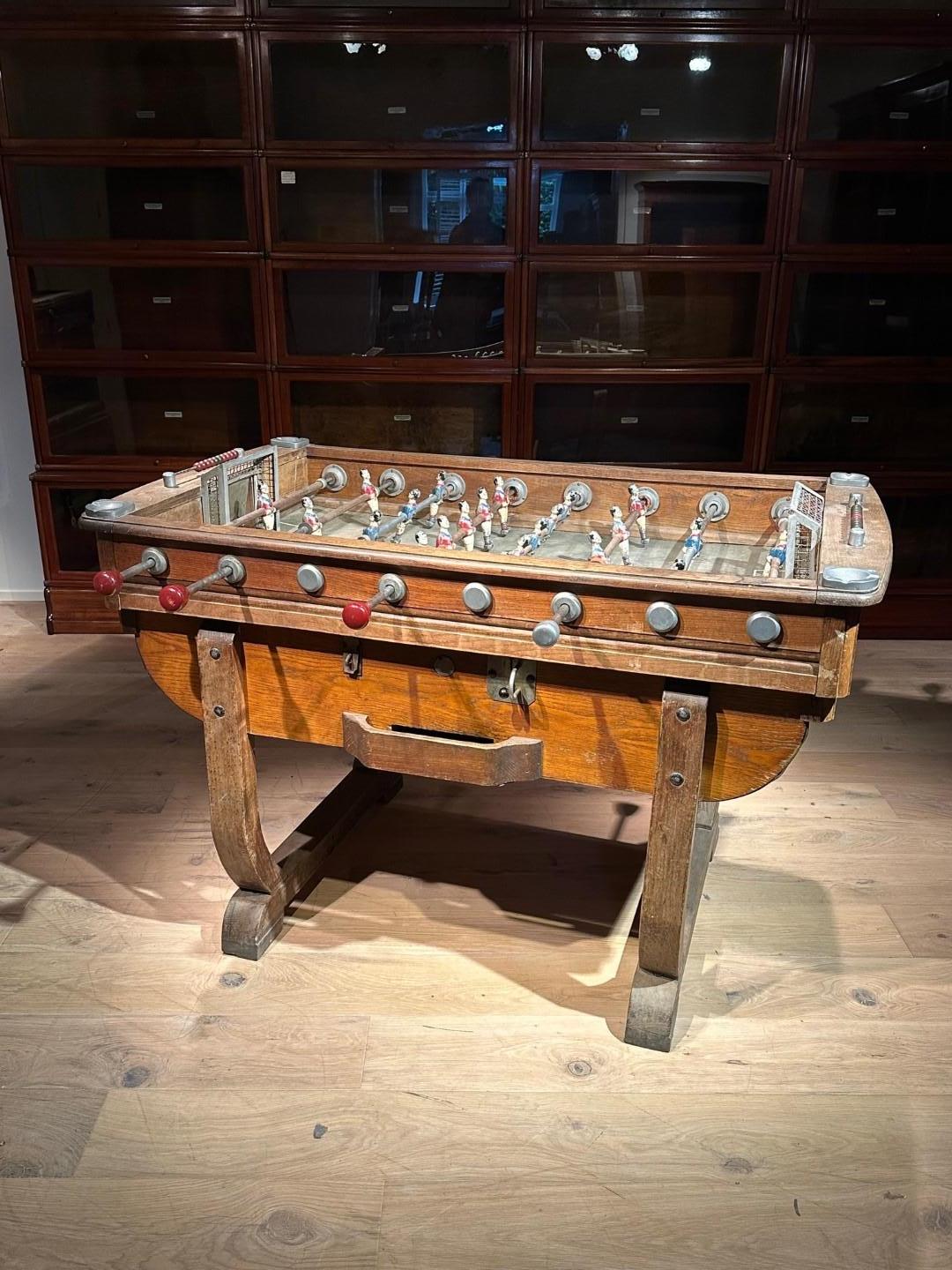 Beautiful vintage foosball table from the 1920s-1940s. The table is made of solid oak except for the playing field and curved bottom. Players are made of metal as are the knobs of the bars. Nice detail the 4 ashtrays! The table is completely in