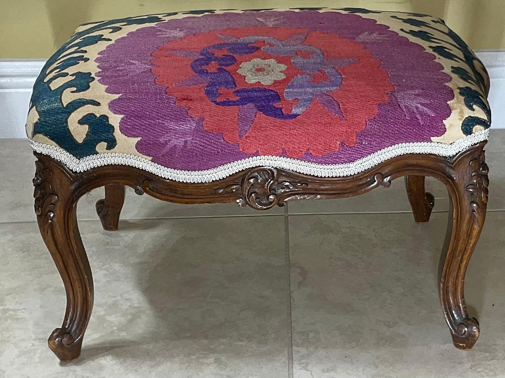 Elegant foot stool made of hand carved wood, upholstered with beautiful antique hand embroidery Suzani textile, beautiful trimming. Newly upholstered, some professionally textile repair see photos, great decorative foot stool.
     