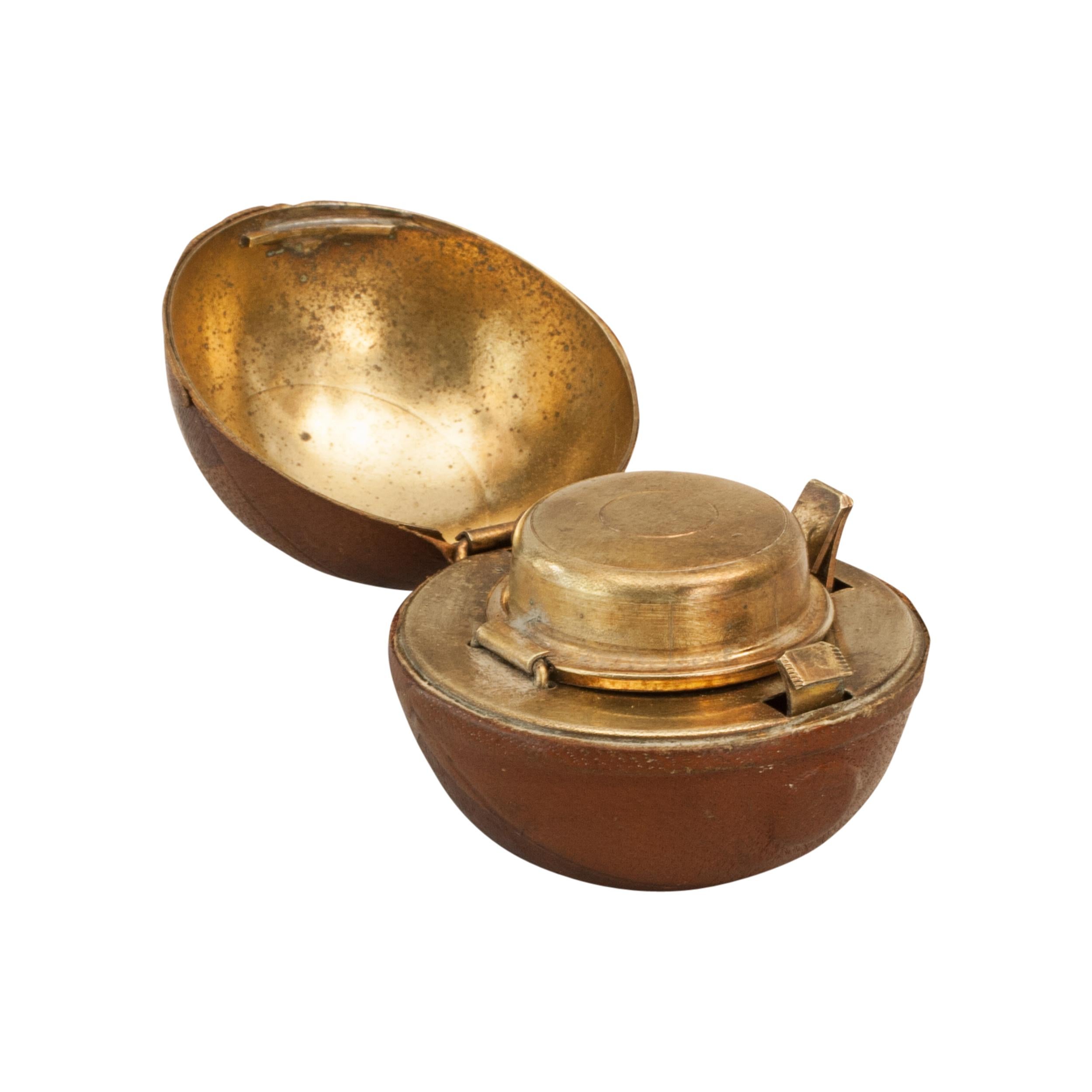 Rare Novelty Football Inkwell.
A wonderful leather covered traveling inkwell in the shape of a football ball. This is a very desirable, rare and unusual object made from brass and covered in imprinted leather to imitate a ball. It is hinged in the