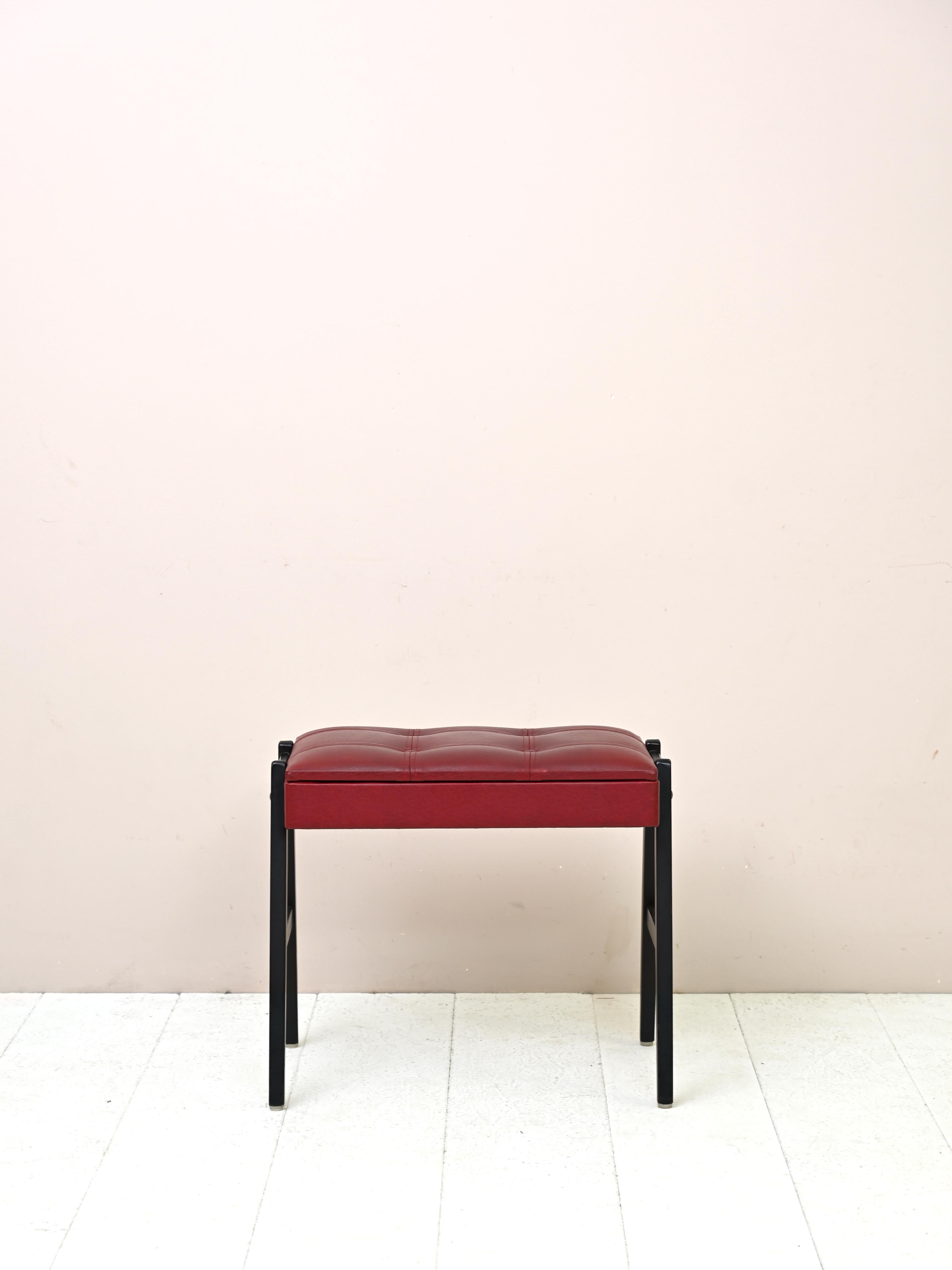 Skandinavischer Hocker aus Holz und Leder
Praktischer originaler Fußhocker aus den 1960er Jahren mit Holzgestell und mit Kunstleder bezogener Sitzfläche
rot. Die Holzbeine sind schwarz lackiert. Unter dem Sitz befindet sich ein kleines