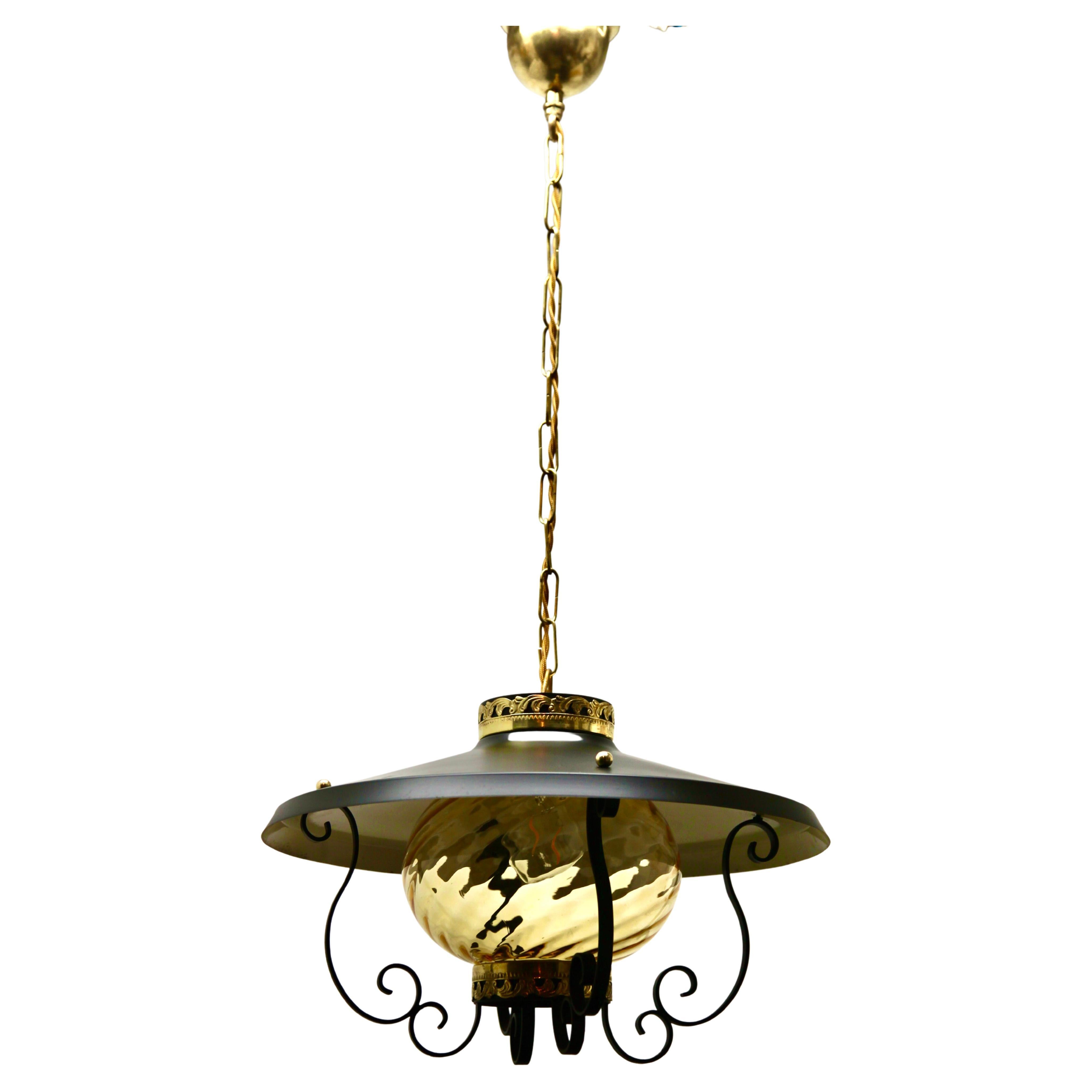 Forget and ribbed glass pendant lamp
Materials:  Ribbed glass globe lampshade. Black painted curved iron slats pleated as a cage. Brass ornamental nuts, screws and parts. Brass chain and canopy. New E27 socket.

Complete restoration
Been