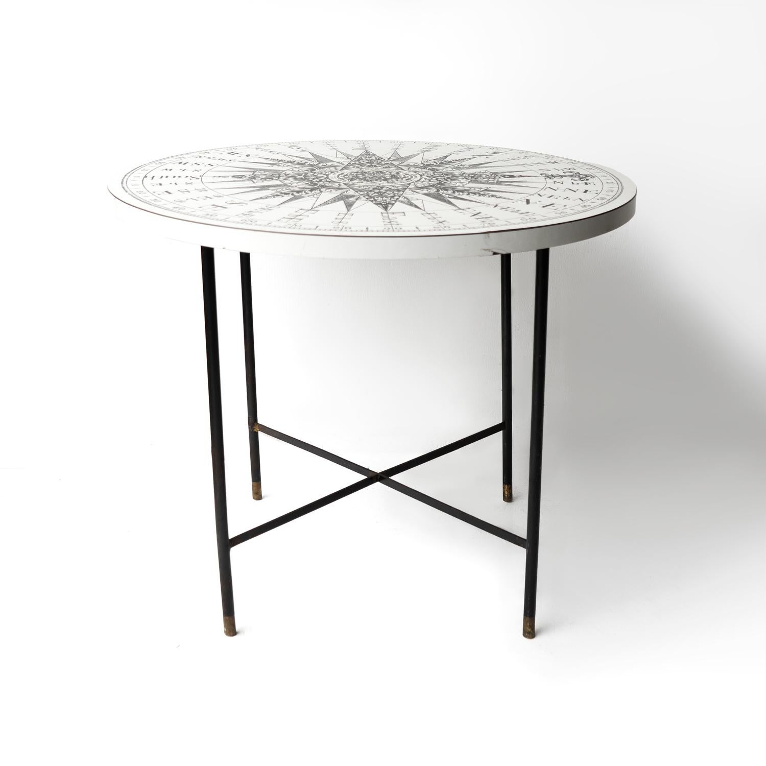 MID-CENTURY CIRCULAR TABLE 

A good quality Formica-topped table with an elegant and stylish black steel base tipped with brass feet. 

The top is printed with a monochrome compass design after an 18th-century drawing by Samuel Dunn and it is