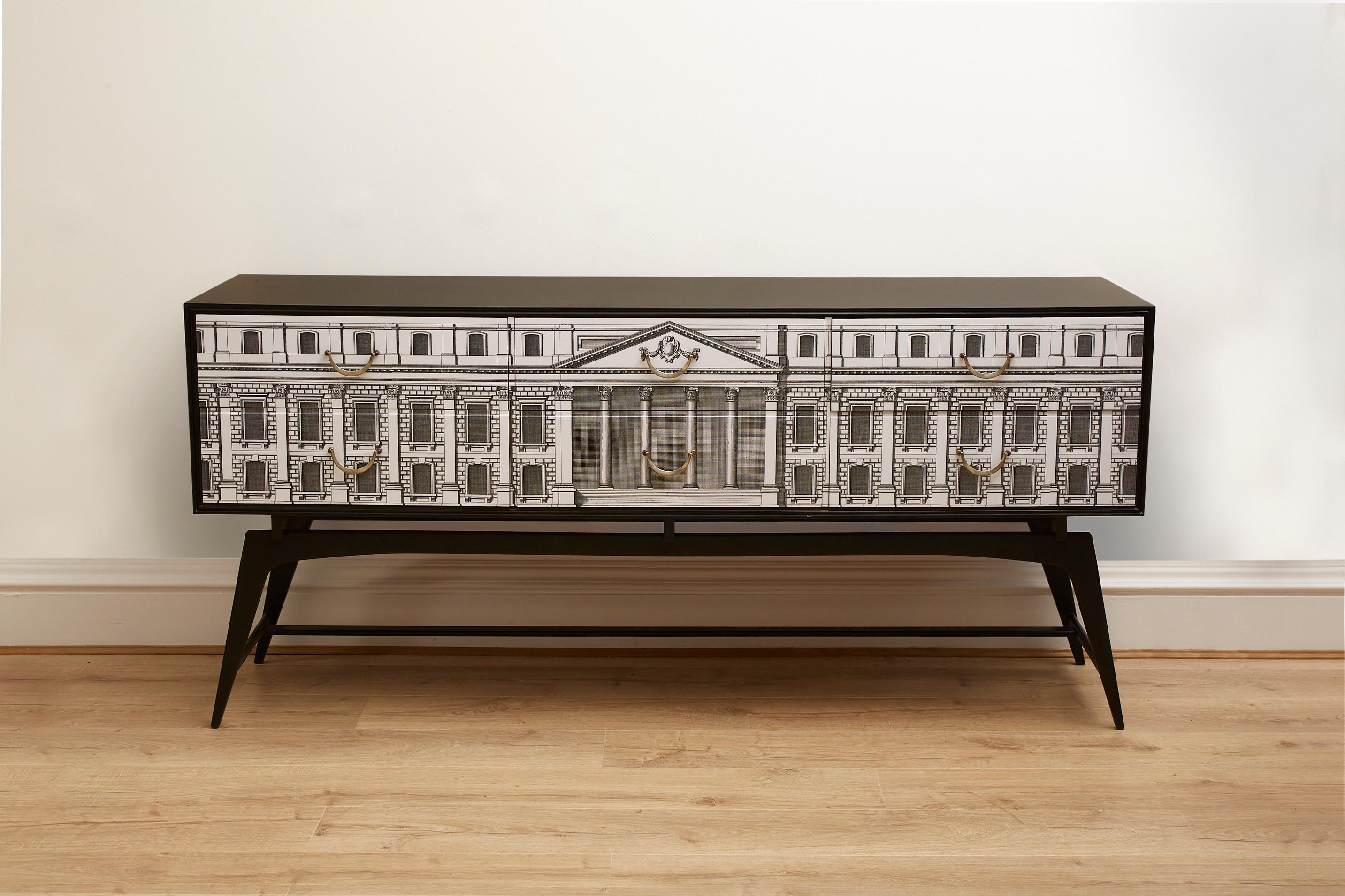 This original 1960's Vintage sideboard / credenza has been restored and re styled professionally.
 
This piece consists of an ebonised body and cross bar base, chrome and brass handles and the front of the piece has been embellished with neo
