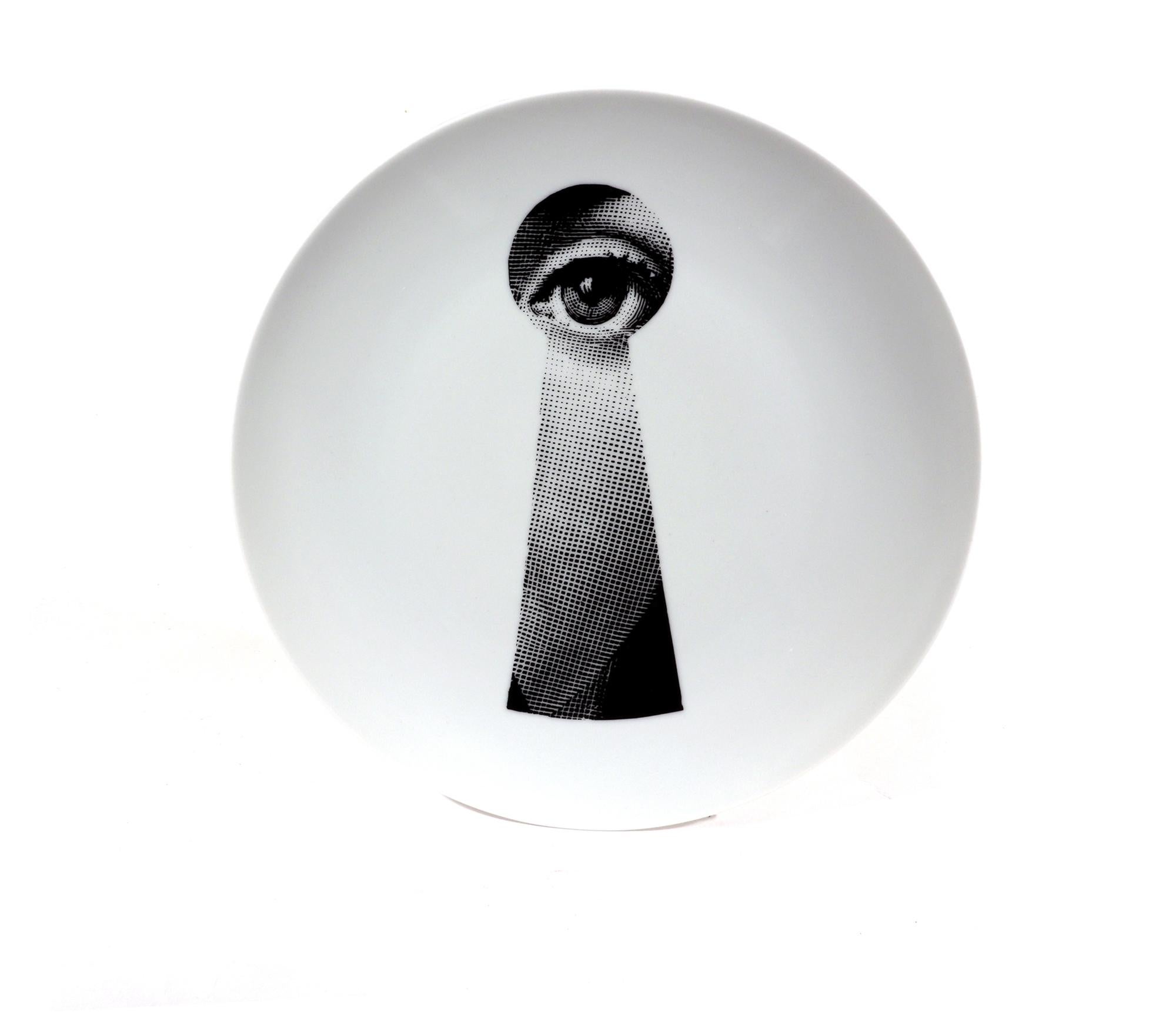 Vintage Fornasetti Porcelain Themes & Variation Plate #14,
The Keyhole,
Atelier Fornasetti

The Surreal Fornasetti porcelain plate in the Themes & Variation pattern depicts a keyhole with the face of Lina Cavalieri, Piero Fornasetti's muse