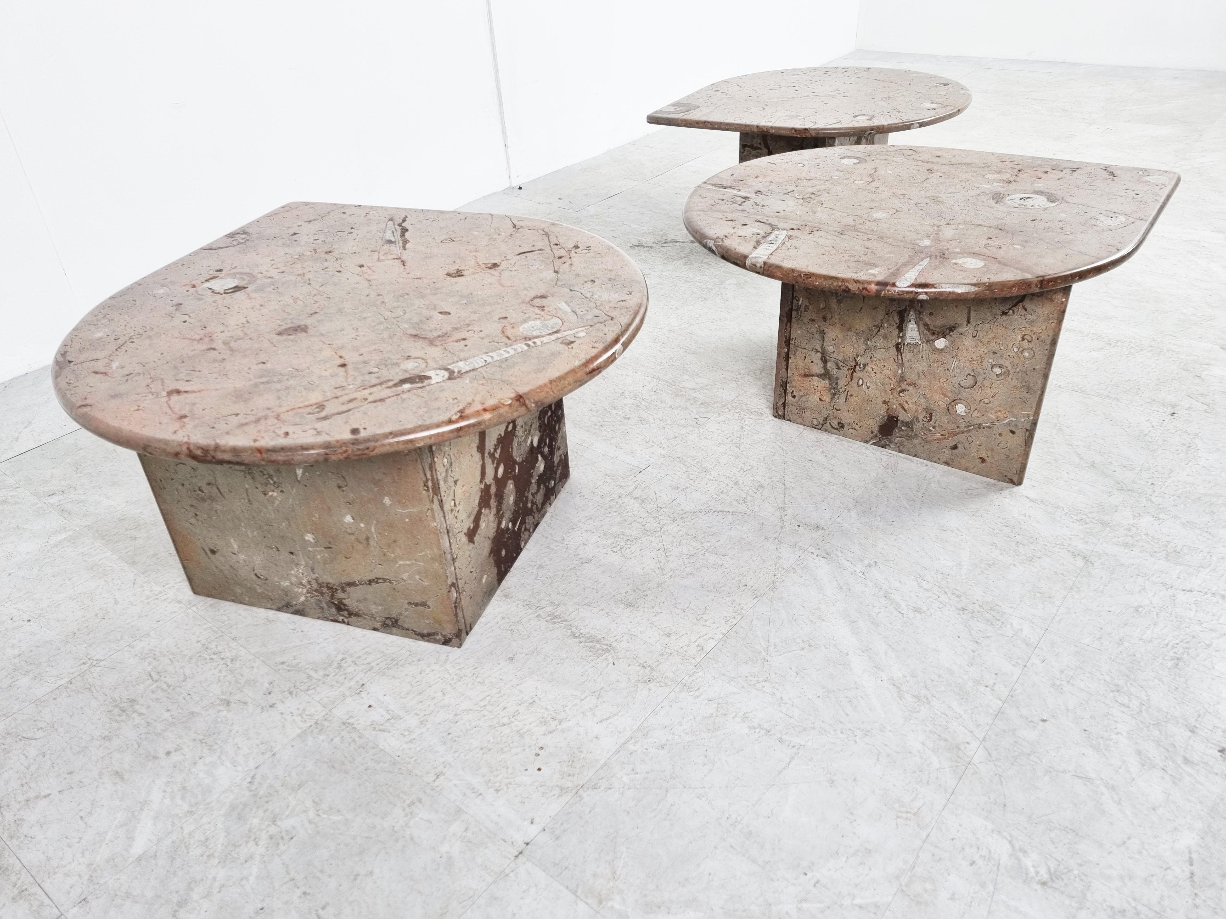 Stunning and rare nest of tables entirely made out of fossil stone with teardrop shaped top and V shaped bases.

Everywhere you look the tables have some cool fossils and details.

They are a nice conversation piece.

Can be put underneath one