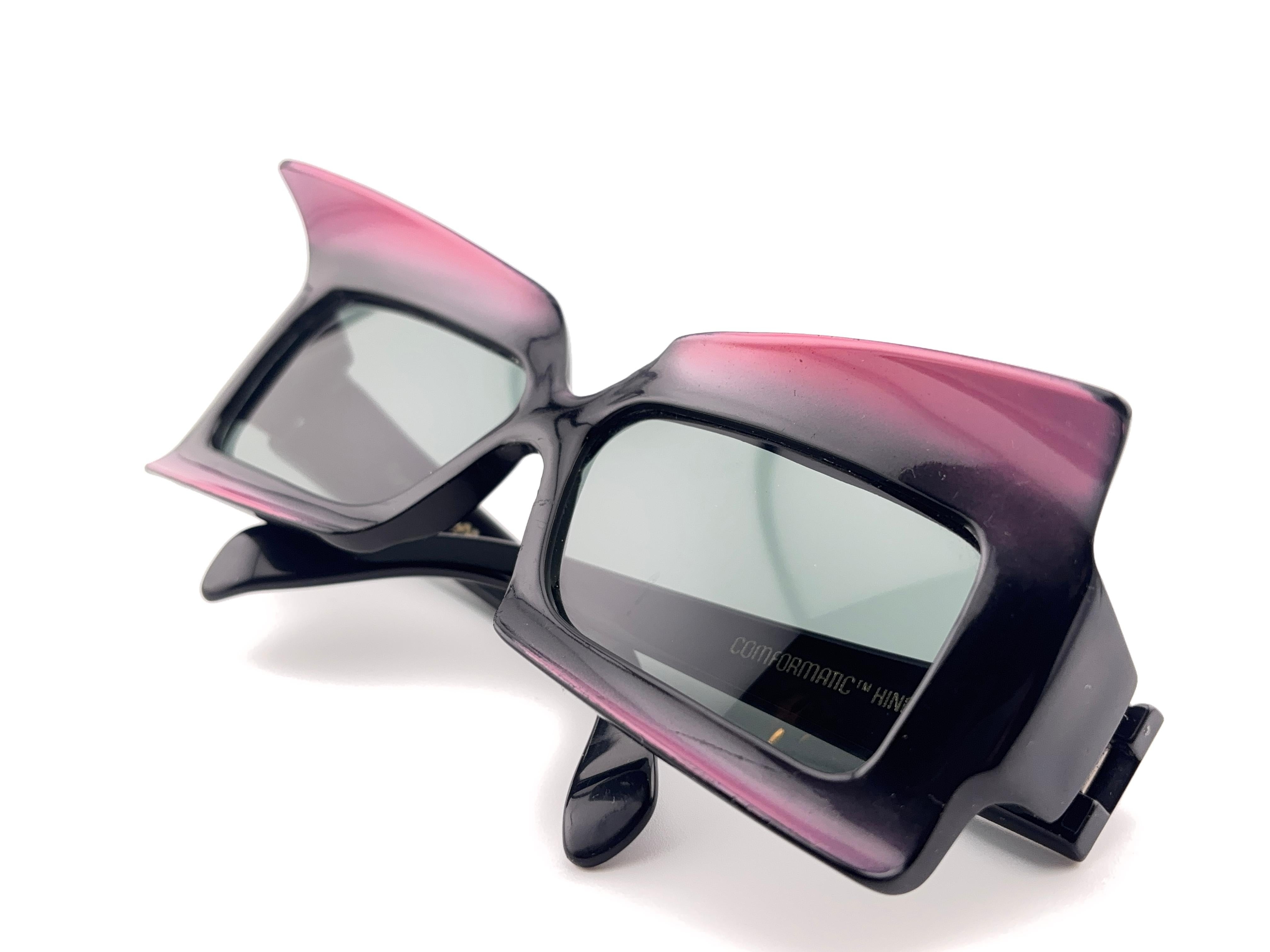 Vintage Fosters Grant monture sculptée noire et framboise, verres gris moyen.

Veuillez noter que cet article présente des signes d'usure sur la monture et des rayures mineures sur les lentilles.

Fabriqué aux Etats-Unis.

Devant : 14 cm 
Hauteur de