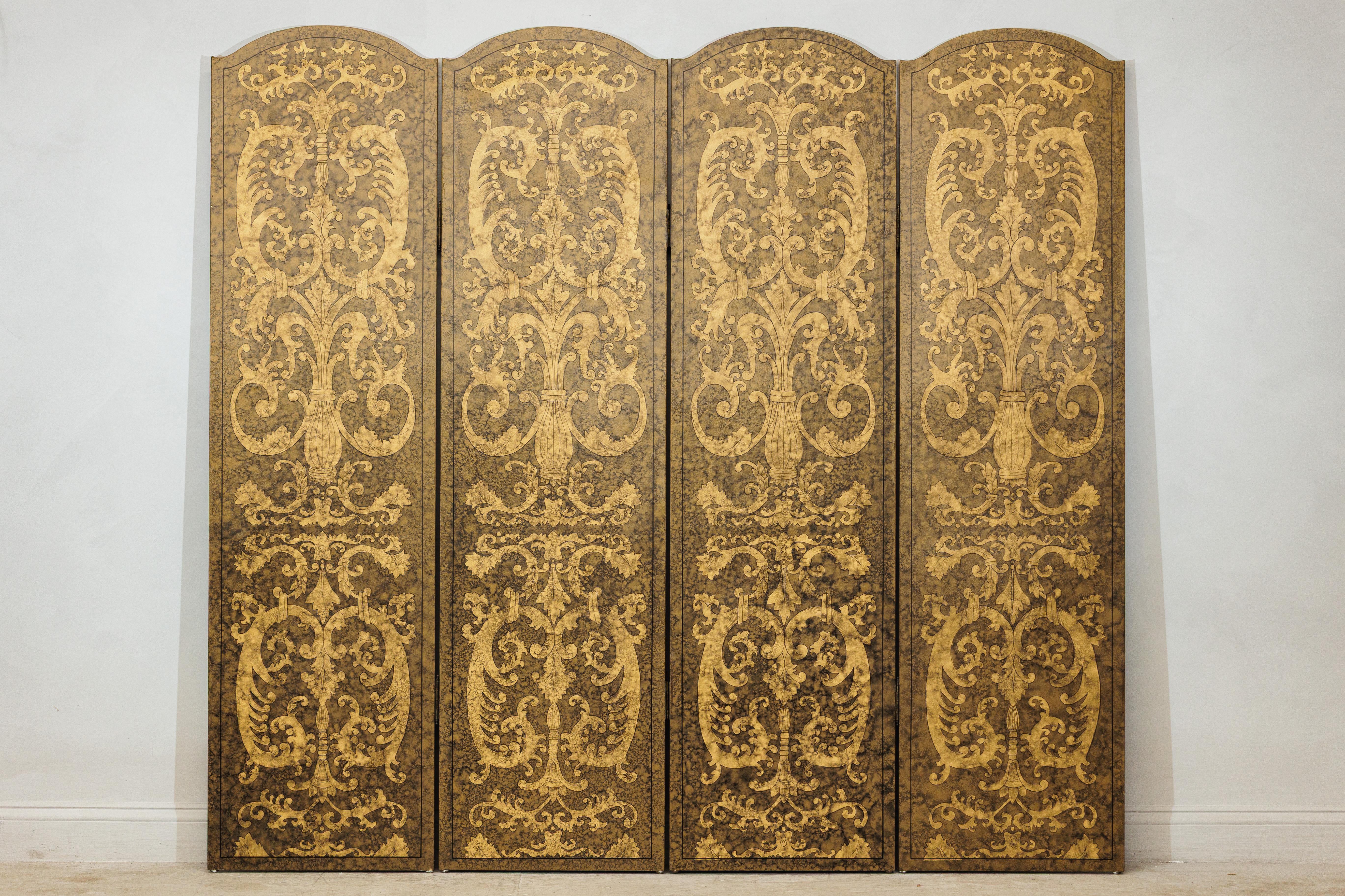 Un sorprendente paravento d'epoca a quattro pannelli con un disegno dorato riccamente stratificato di motivi a fogliame e urna ispirati all'ornamentazione rinascimentale e barocca. Ogni pannello alto e arcuato mostra una composizione simmetrica di