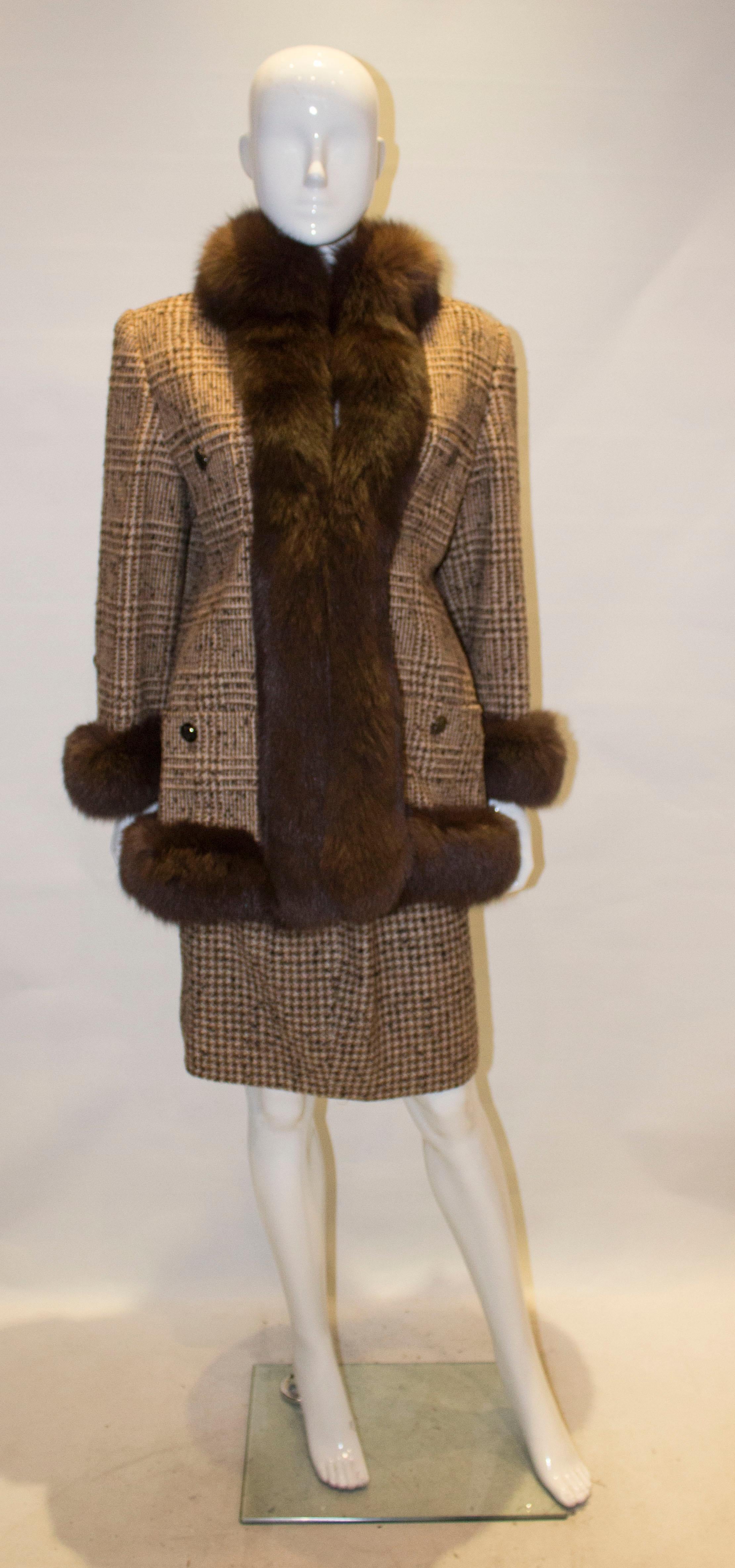 An indulgent vintage skirt suit in a brown and white wool ( 80% alpaca, 20% wool), with fox fur trim. The jacket has four pockets on the front , with no fastenings  but these could easily be added. It has fox fur cuffs and fur trim around the edge.