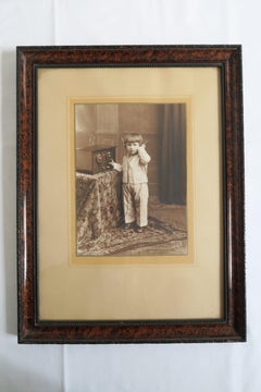 Fotografía vintage enmarcada de un niño escuchando la radio, hacia 1920