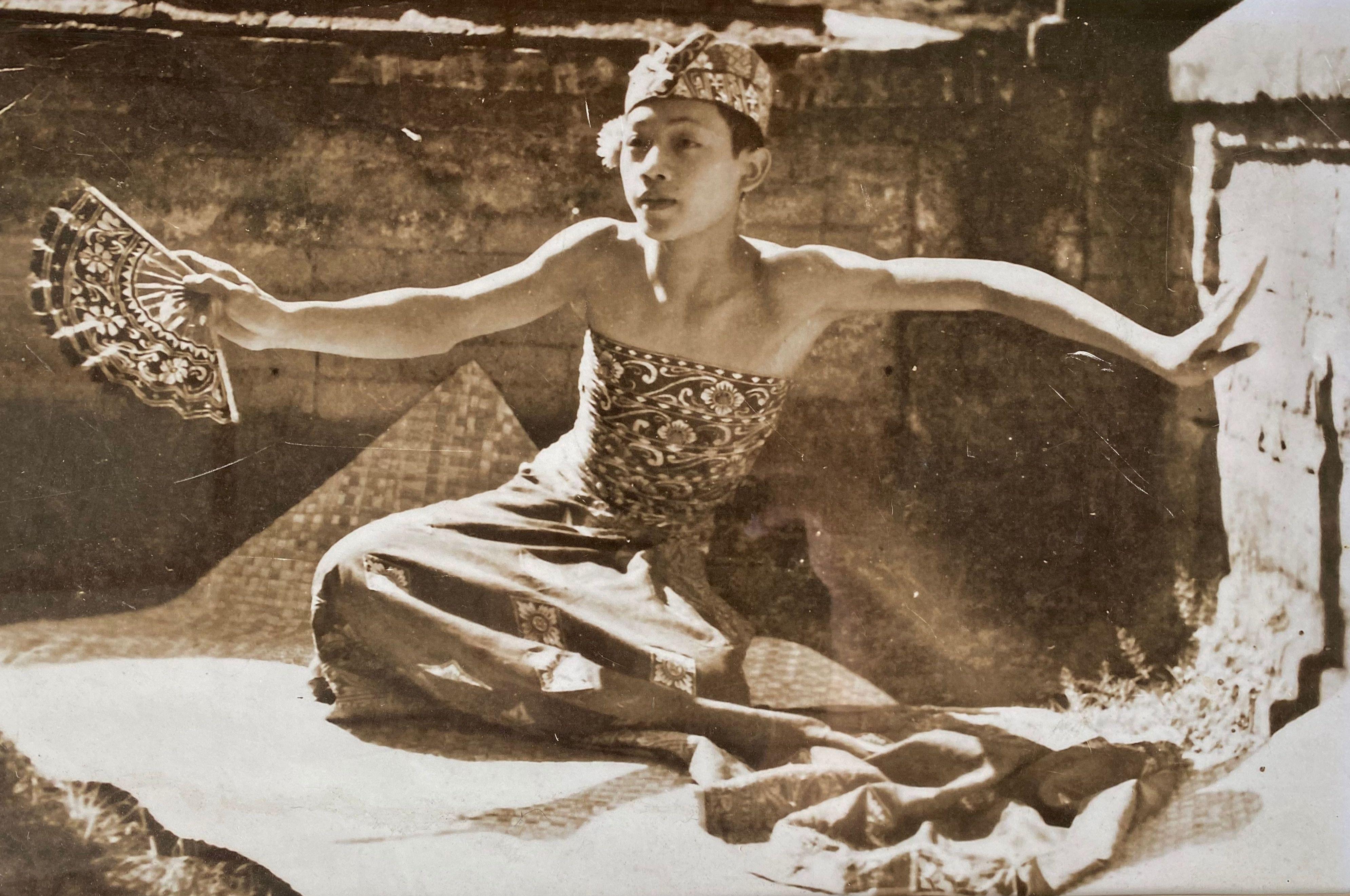 Ein gerahmtes Vintage-Foto aus Bali, Indonesien, mit Glasfront. Das Schwarz-Weiß-Foto zeigt einen jungen Balinesen in traditioneller Zeremonialkleidung bei den Proben für eine Aufführung. Der Rahmen hat eine schöne altersbedingte Abnutzung und