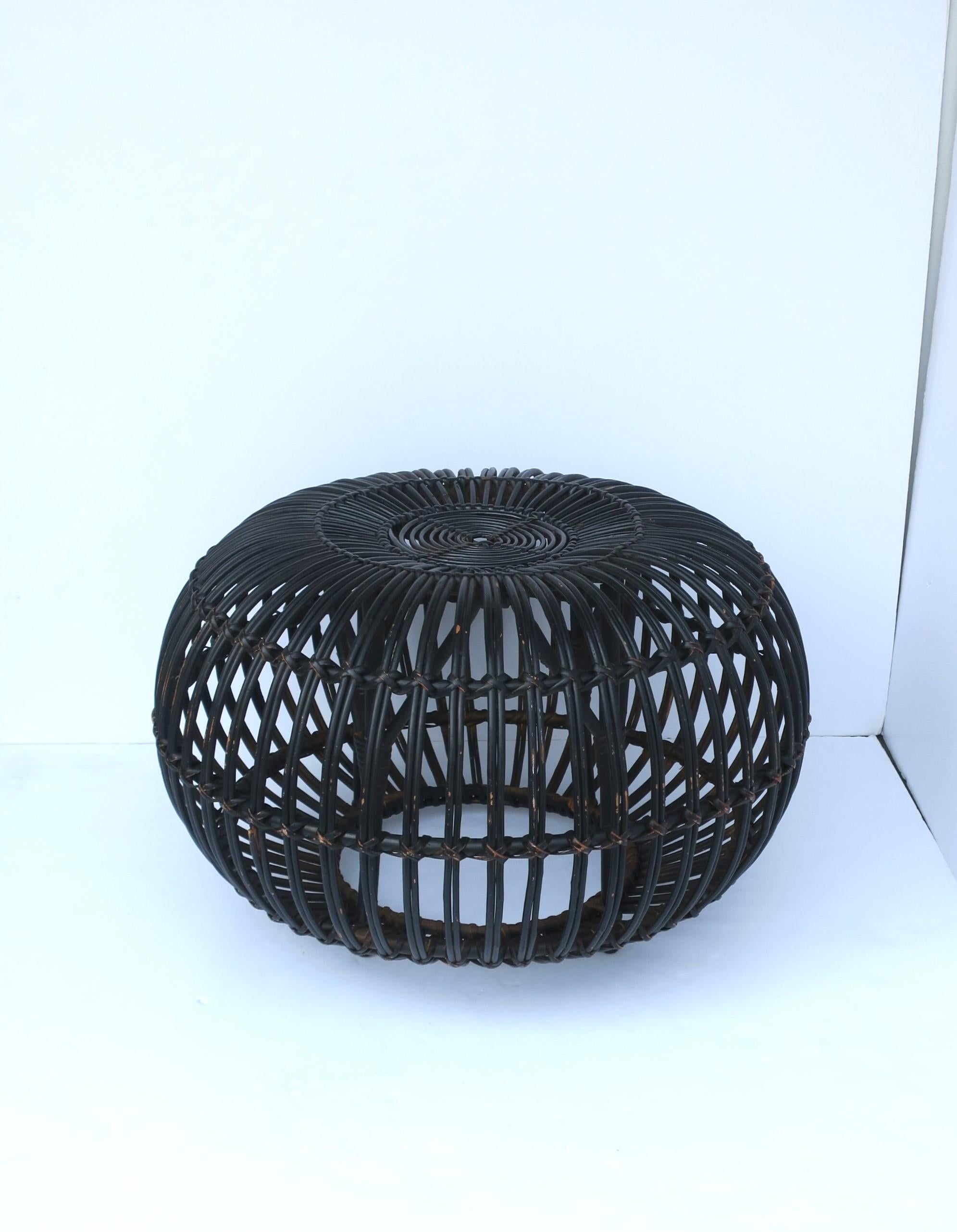 A vintage Italian wicker rattan ottoman pouf in black, attributed to designer Franco Albini, circa mid-20th century, Italy. A chic piece indoors or covered outdoor area, pool house, etc. Use as an ottoman stool seat (its intended use), to