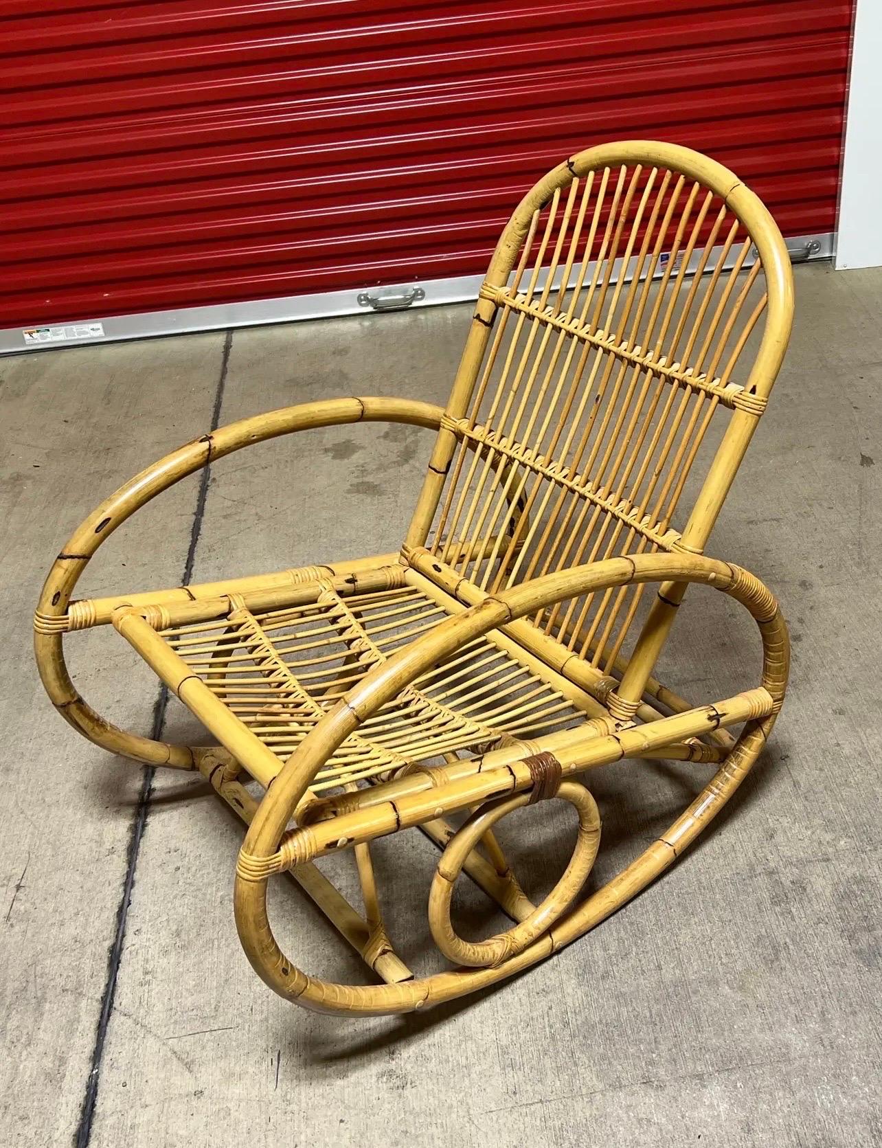 in vendita questa bellissima sedia a dondolo vintage realizzata in bambù piegato e rattan. La sedia è molto ben fatta e confortevole