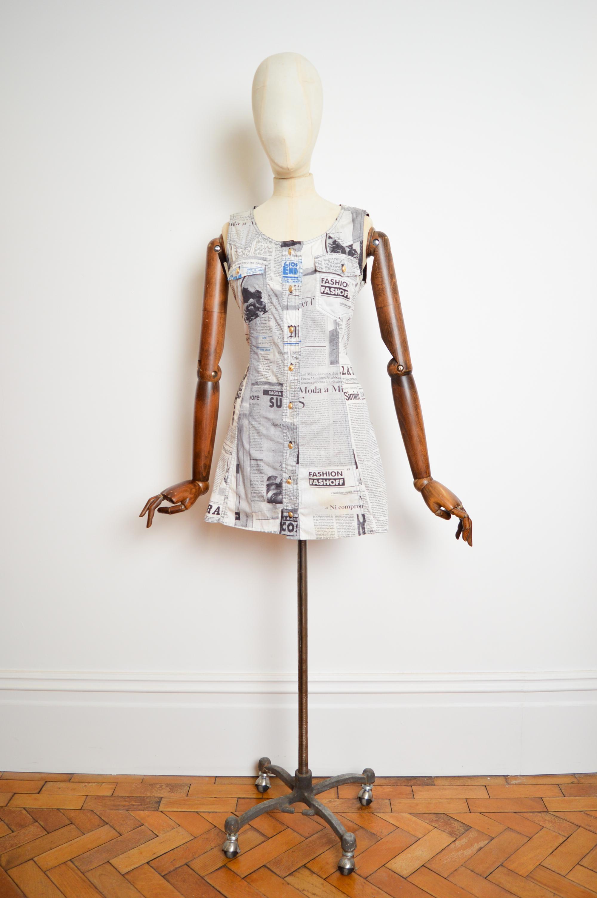 A Brilliant early nineties Franco Moschino button down mini dress in a chic newspaper print.

MADE IN ITALY.

Franco Moschino is known for his tongue in cheek, humorous designs this item is from the iconic 'Moschino Jeans' line, synonymous with