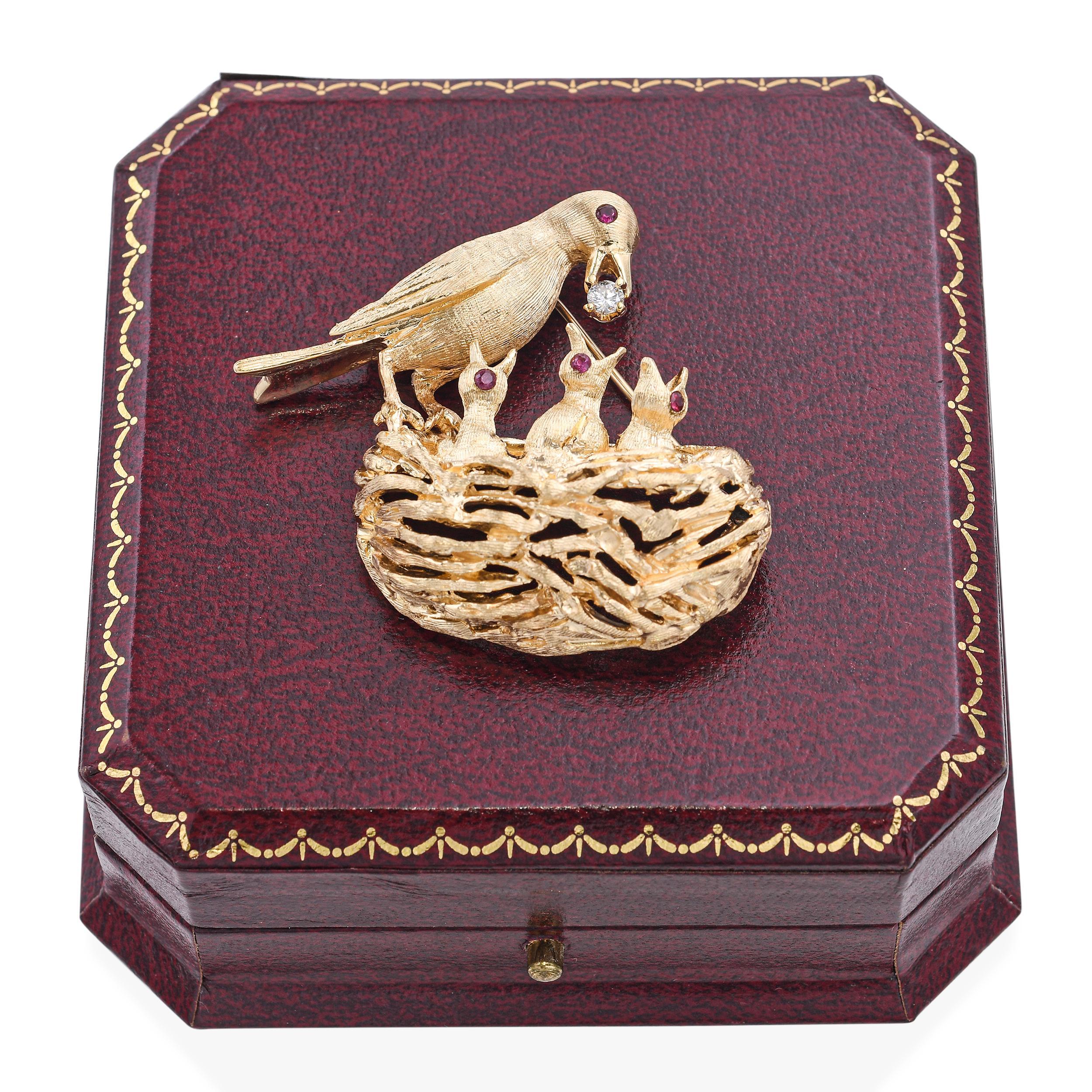 Exquise broche vintage en or en forme d'oiseau et de nid. Cette charmante broche en or est ornée d'un oiseau perché sur un nid. L'oiseau tient un diamant étincelant dans son bec, tandis que le nid abrite trois oisillons aux yeux de rubis vibrants.