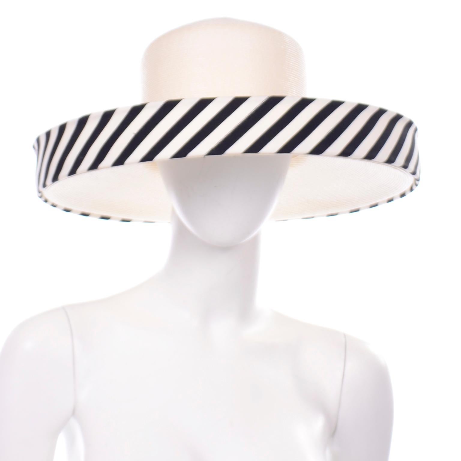This sensational vintage ivory woven summer hat has an upturned brim that is lined with black and white stripes. There is a small knotted bow on the side and the hat has the Frank Olive for Saks Fifth Avenue label.
This incredible Frank Olive hat os