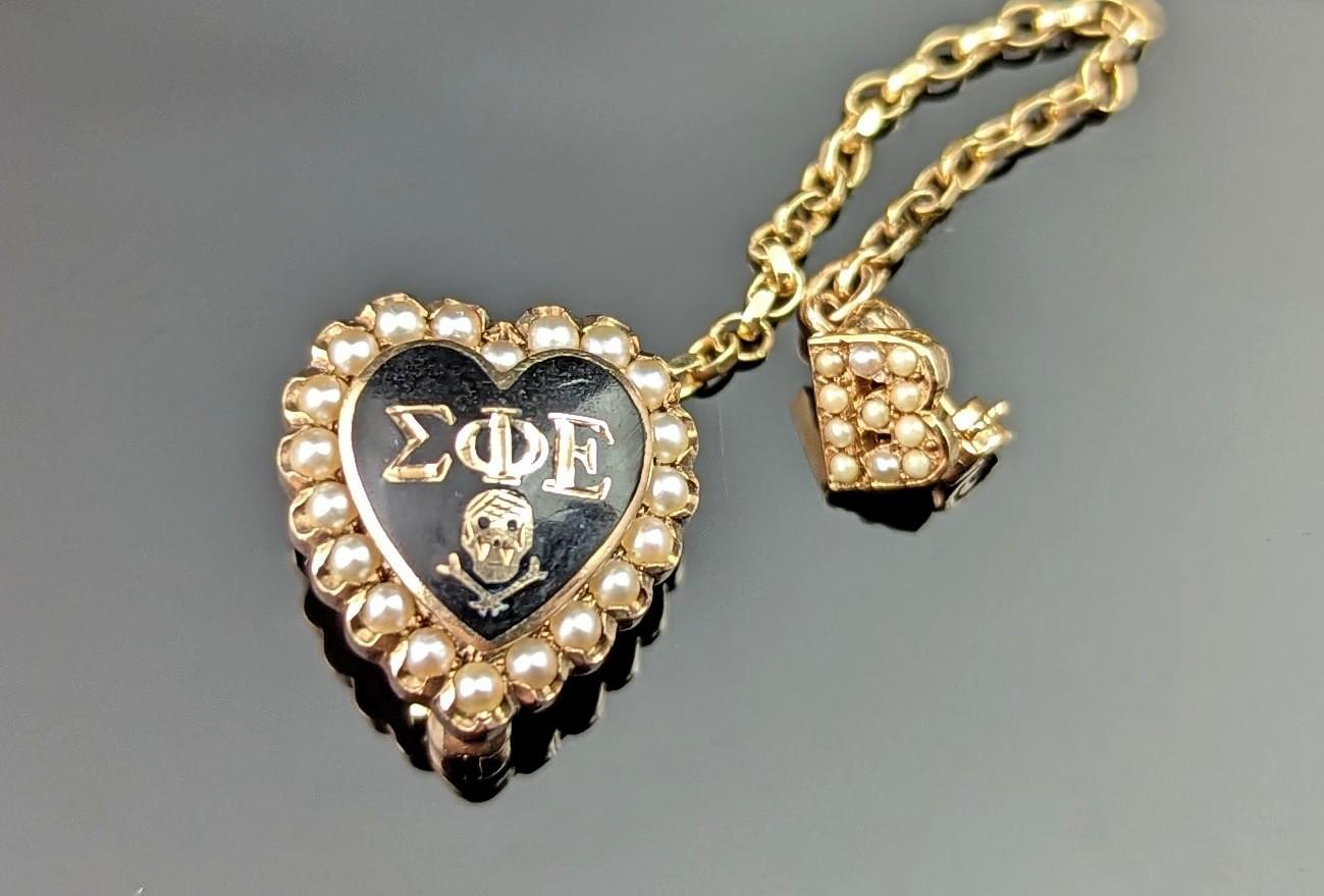 This Vintage Sigma Phi Epsilon fraternity brooch or pin is really quite amazing if we don't say so ourselves, so much detailing in a tiny package.

Crafted in 10ct gold with a light aged patina, the brooch is a puffy heart shape, enamelled in rich