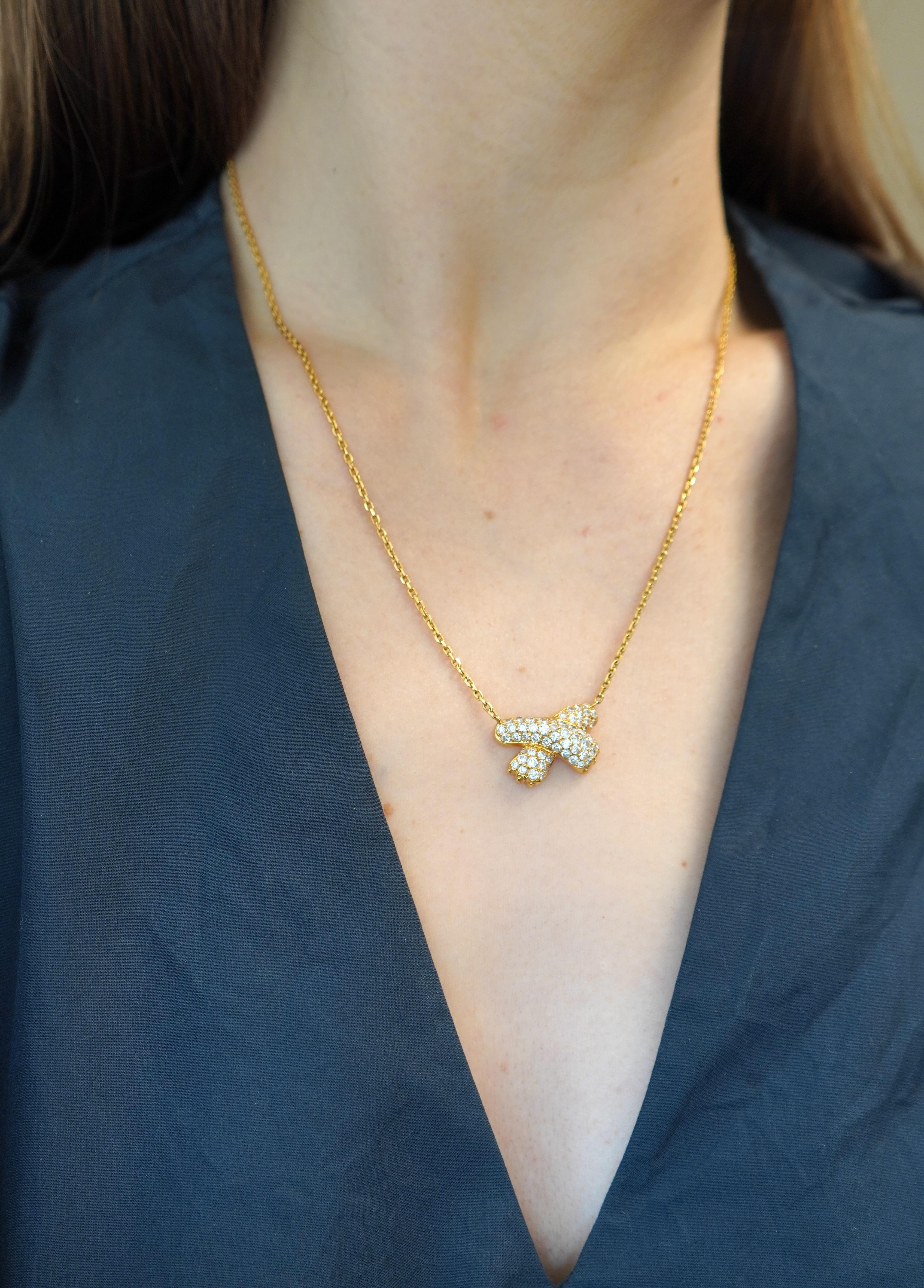 Questa collana Fred Paris vintage presenta un pendente a nastro con pavé di diamanti incastonati in oro giallo 18 carati. Il ciondolo misura 7/8