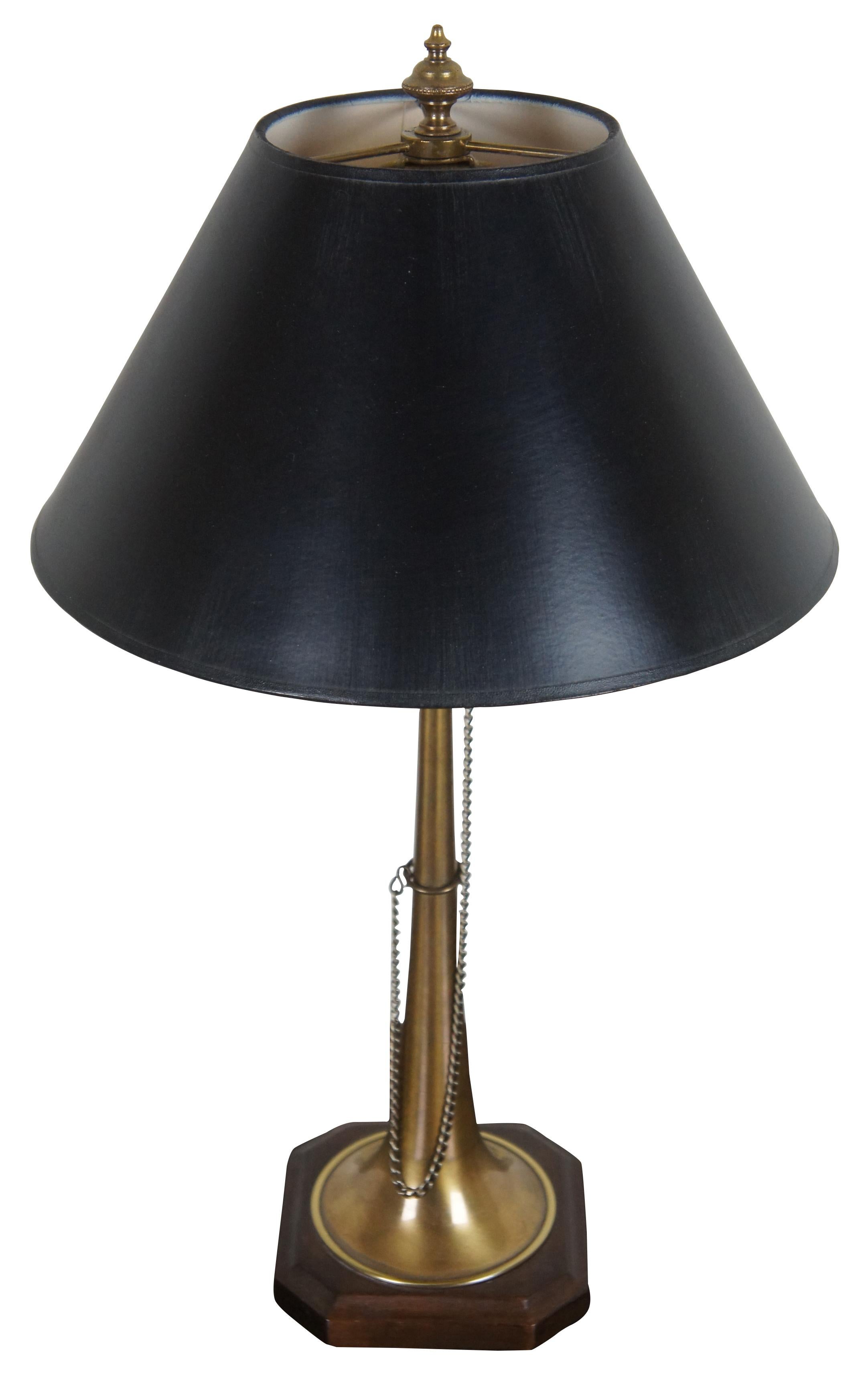 Vintage Frederick Cooper brass table lamp in the shape of a straight brass horn mounted on a wood base, with a black shade.

Measures: 5.5” x 5.5” x 16” / Shade - 12.25” x 6.25” / Height with shade – 22” (Width x Depth x Height/Diameter x Height).