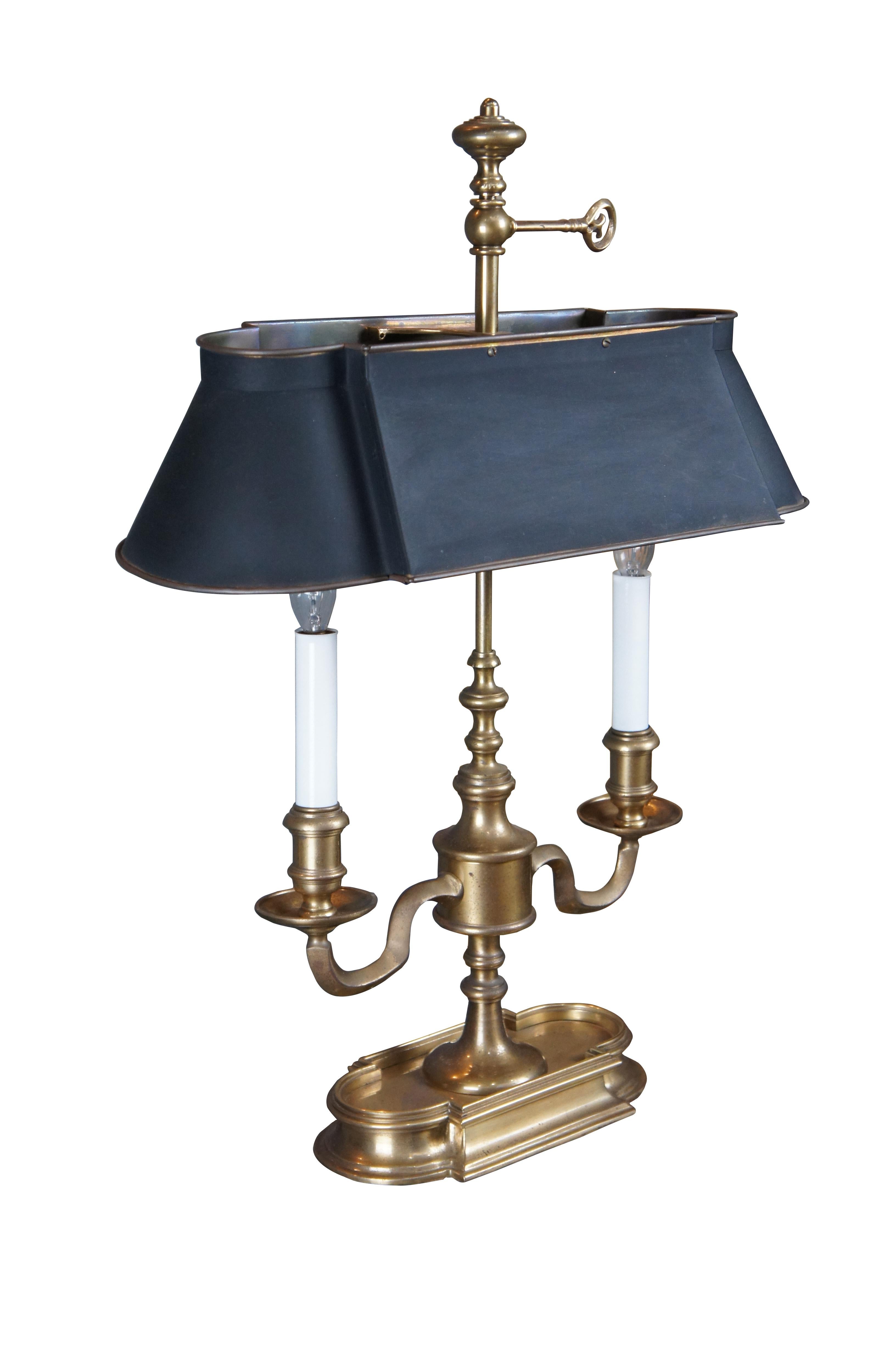 An exquisite Bouillotte lamp by Frederick Cooper, circa 1970s. Features a brass frame with two candlestick lights over an asymmetrical quatrefoil base. The lamp is fitted with a back tole shade in matching form to the base. Great for use on a desk,