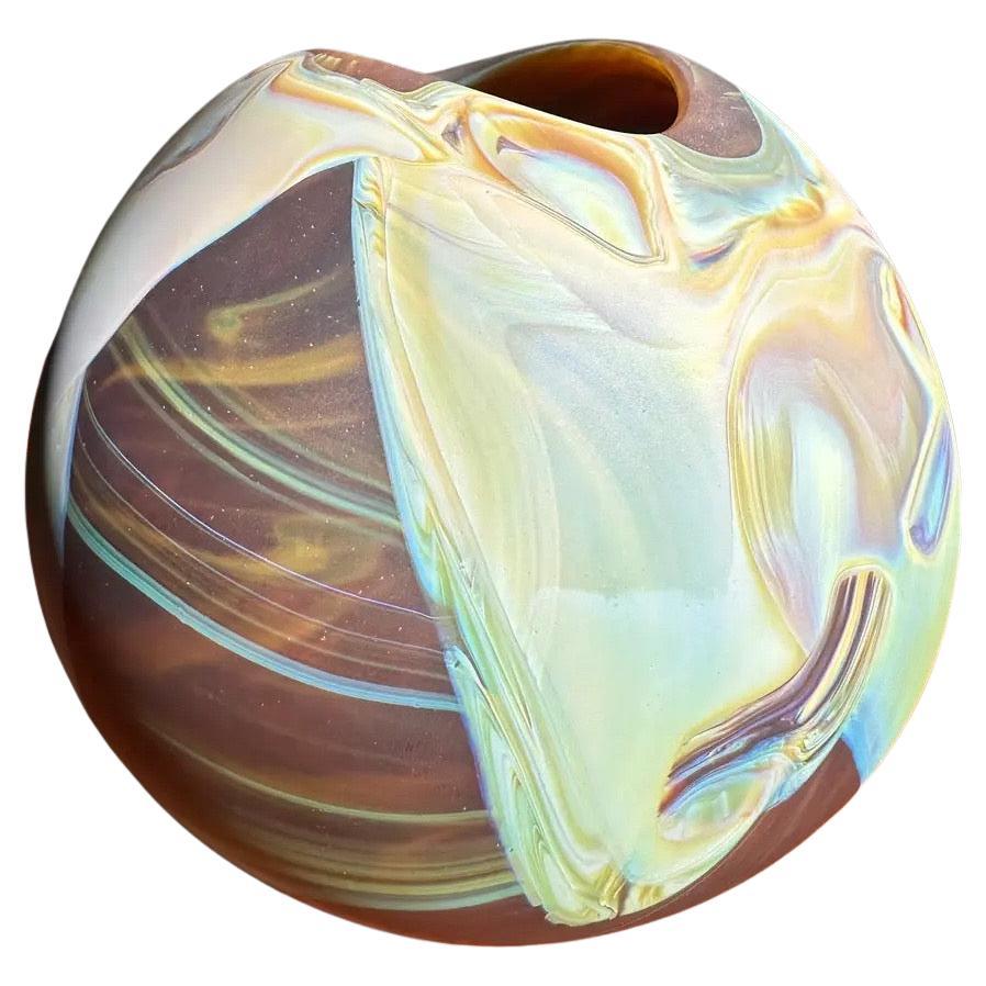 Beautiful signed and dated 2006 satin finish art glass ball vase by Frederick Warren. Shades of light green and blue swirls on a brown base, striking piece.

No chips or cracks, circular outline of extra glass on inside of vase likely from