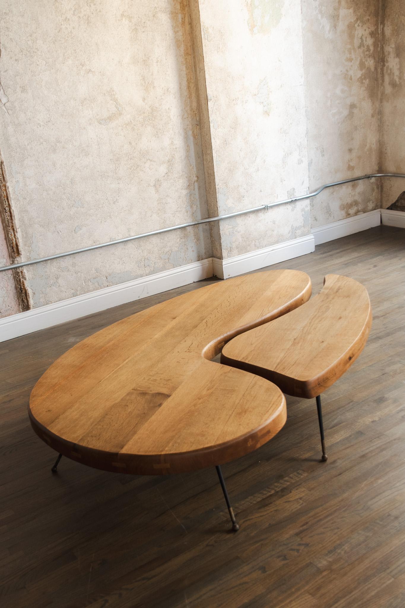 Paire de tables basses vintage en chêne, pieds en métal, des années 1950. Ils s'emboîtent les uns dans les autres pour créer une belle forme organique amibienne. Le bois est en très bon état et est un beau chêne chaud. 

grande taille :
total 66' w